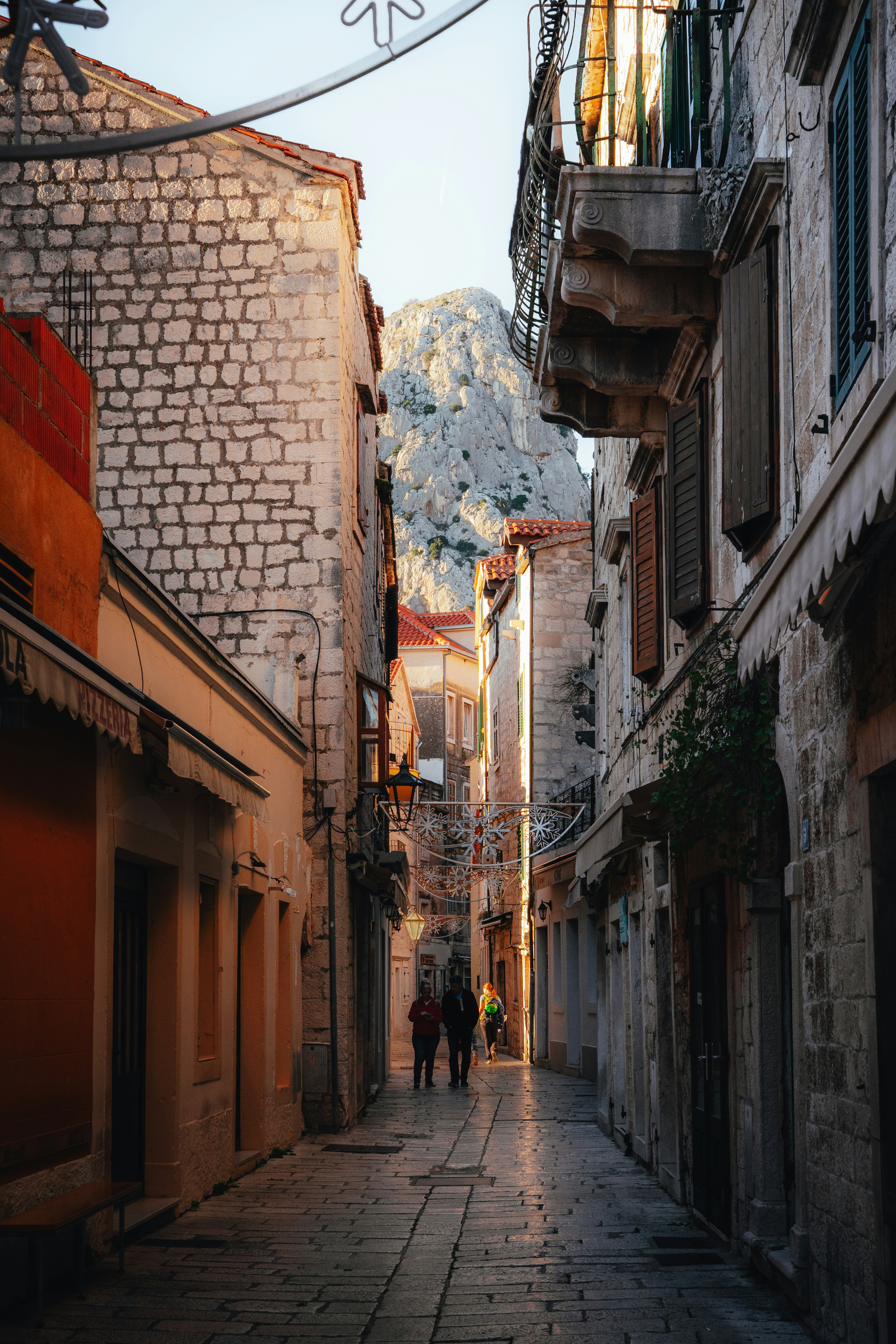 Calle estrecha de omiš flanqueada por antiguos edificios de piedra