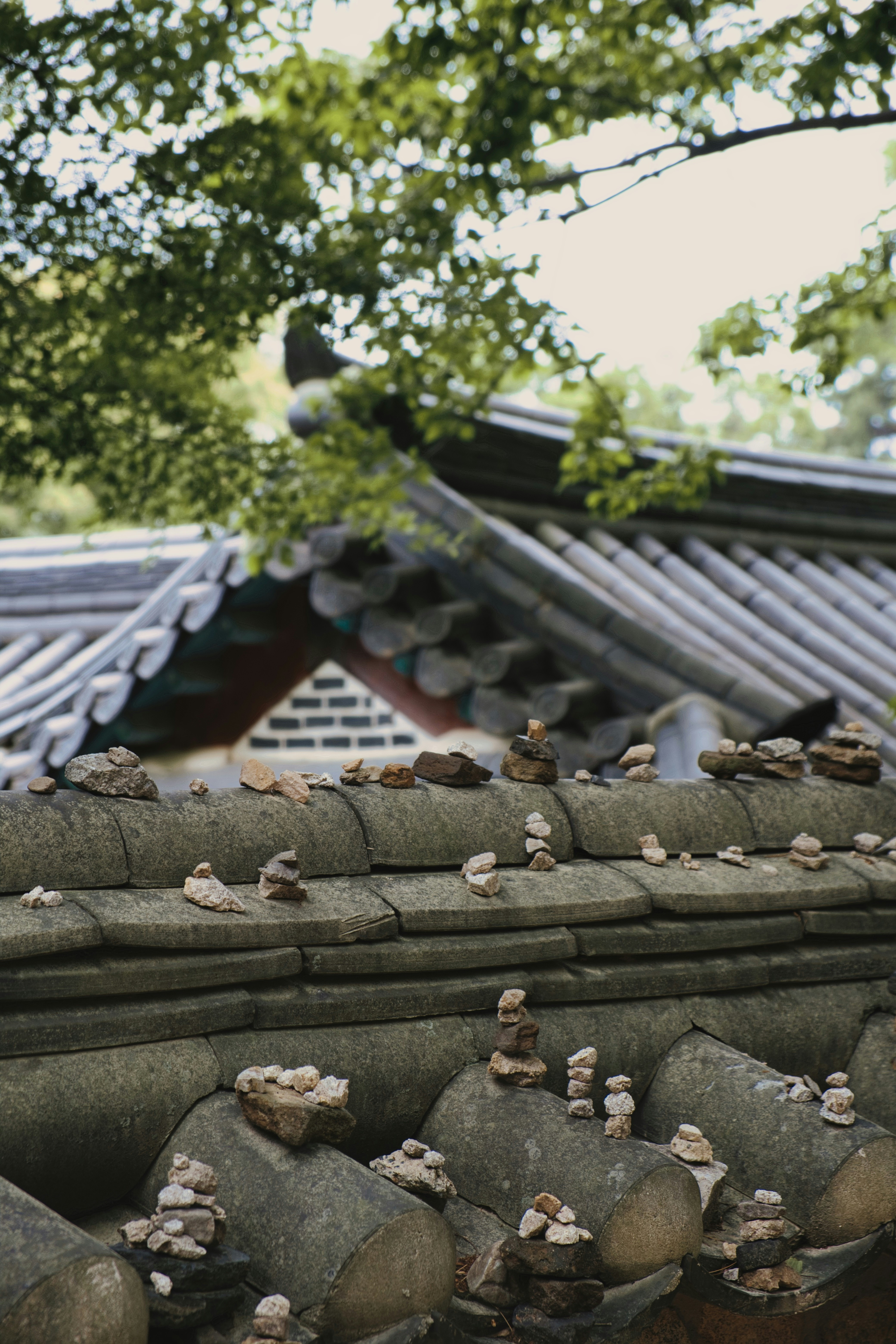 Piedras de oración apiladas sobre la pared y el tejado tradicionales del templo.