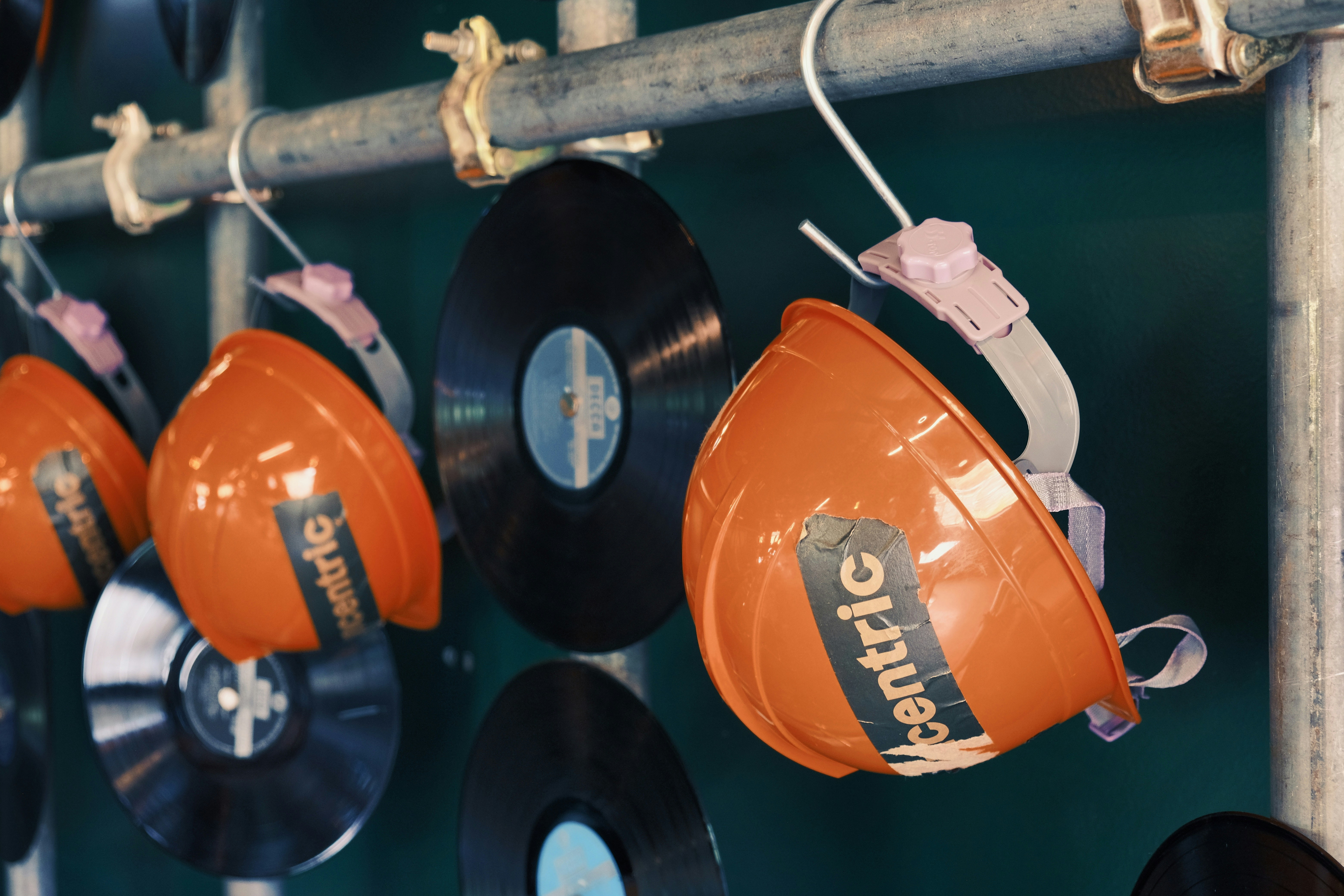 Cascos naranjas y discos de vinilo colgados de un bar.