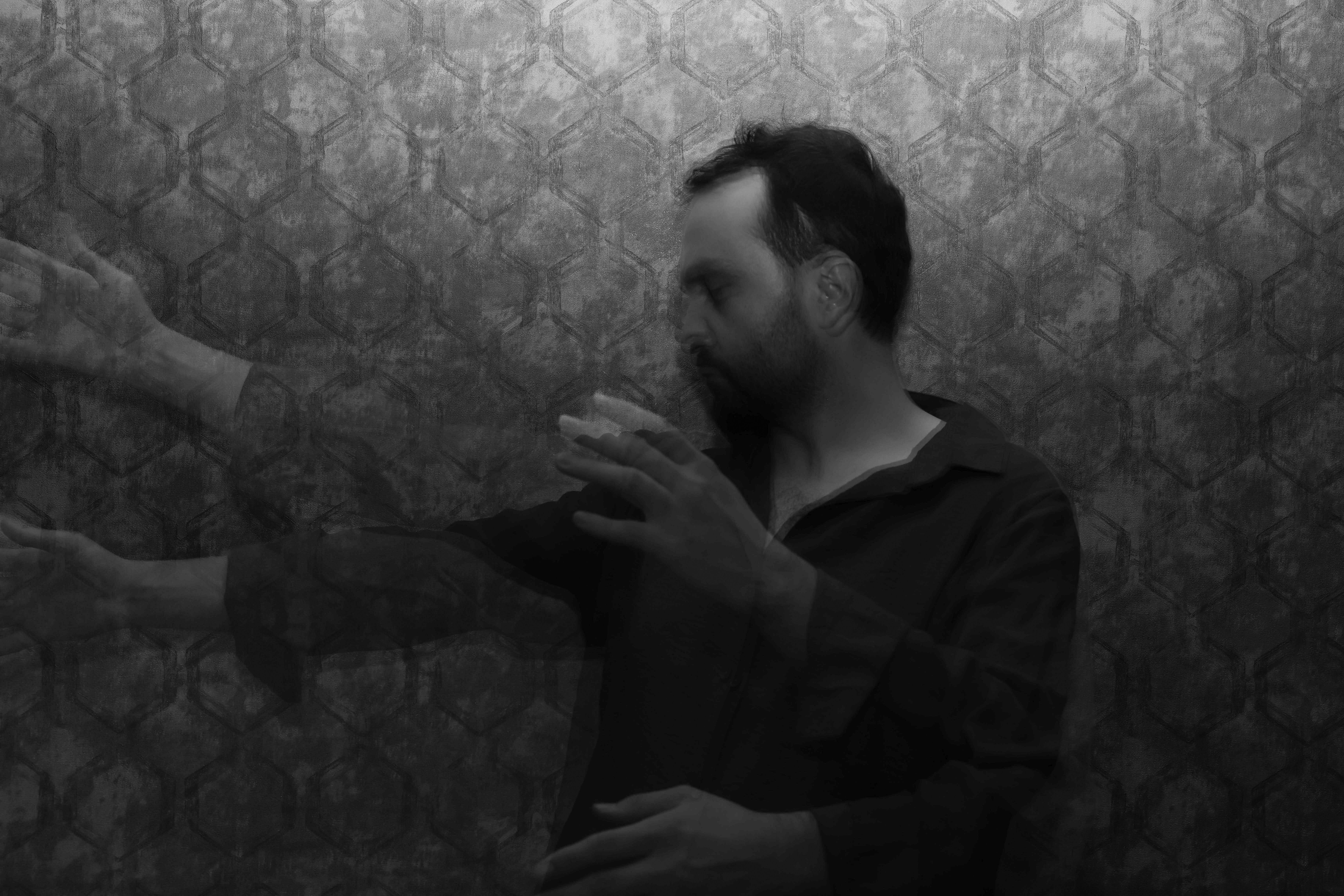 Man with beard against patterned wall, motion blur