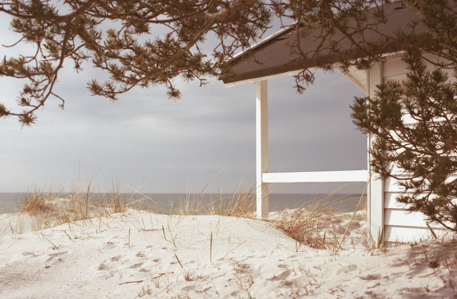 White beach house on a sand dune overlooking the sea