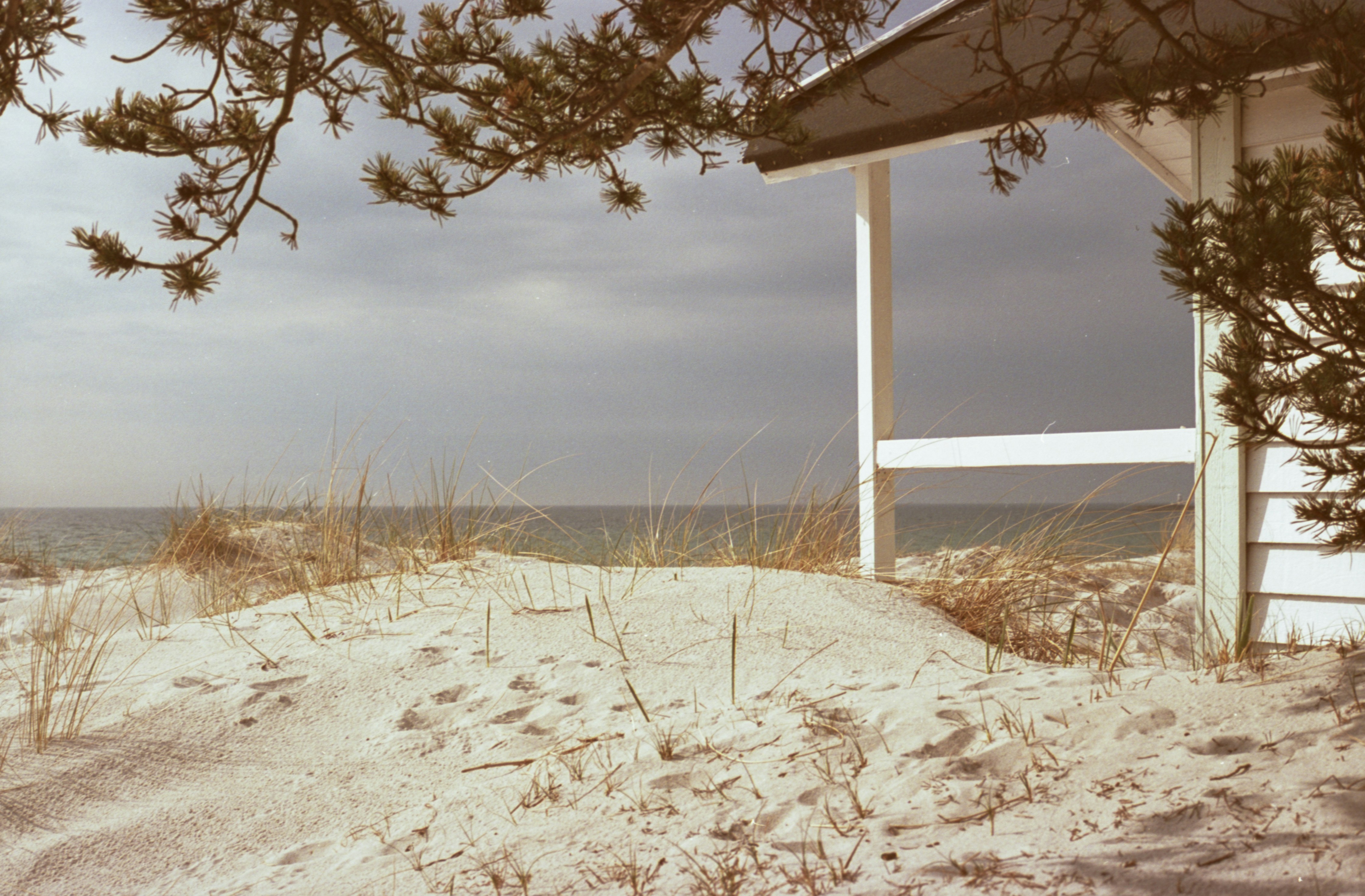 Sandy beach with a white structure overlooking the ocean.