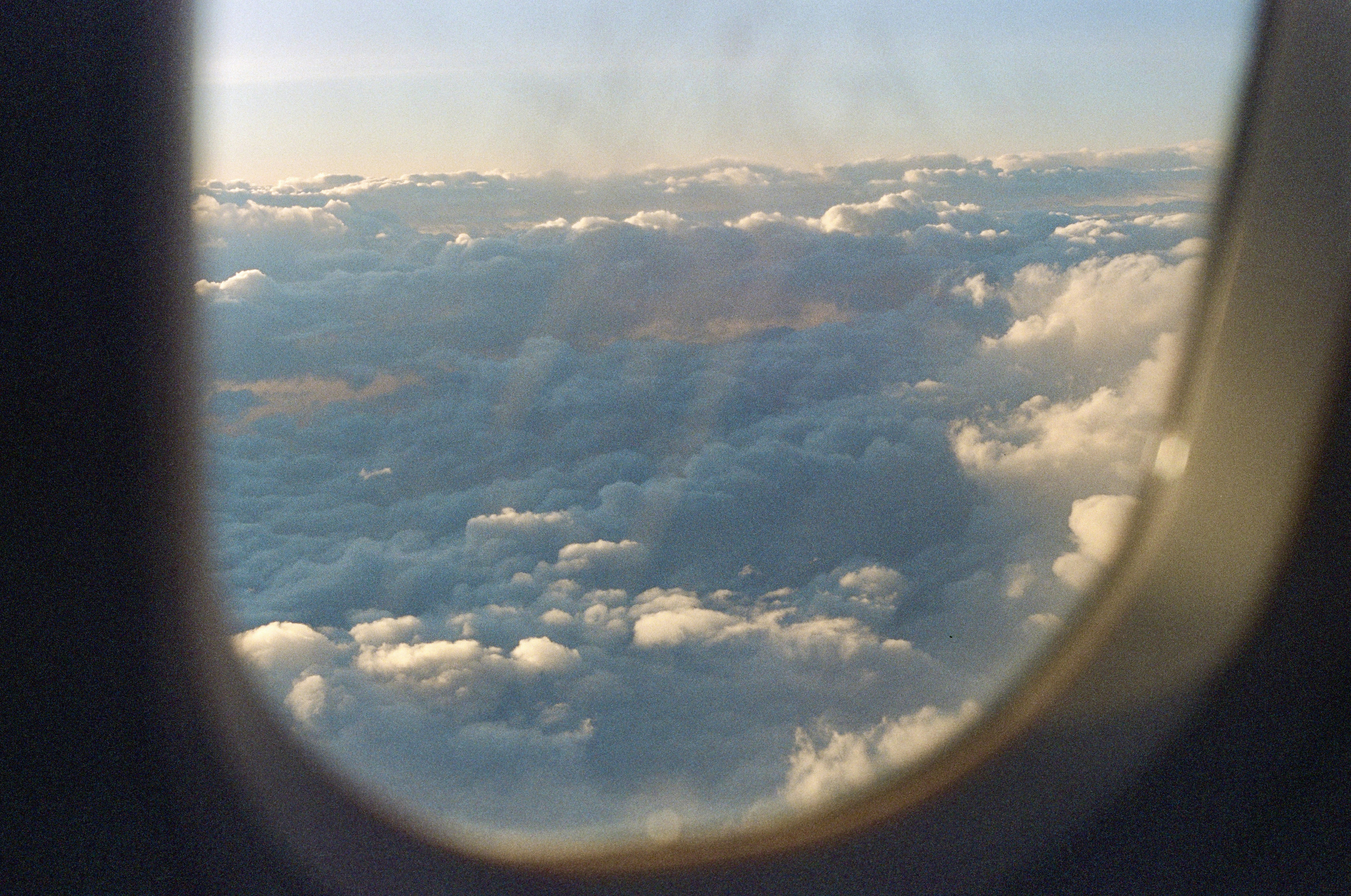 Fluffy clouds viewed through an airplane window.