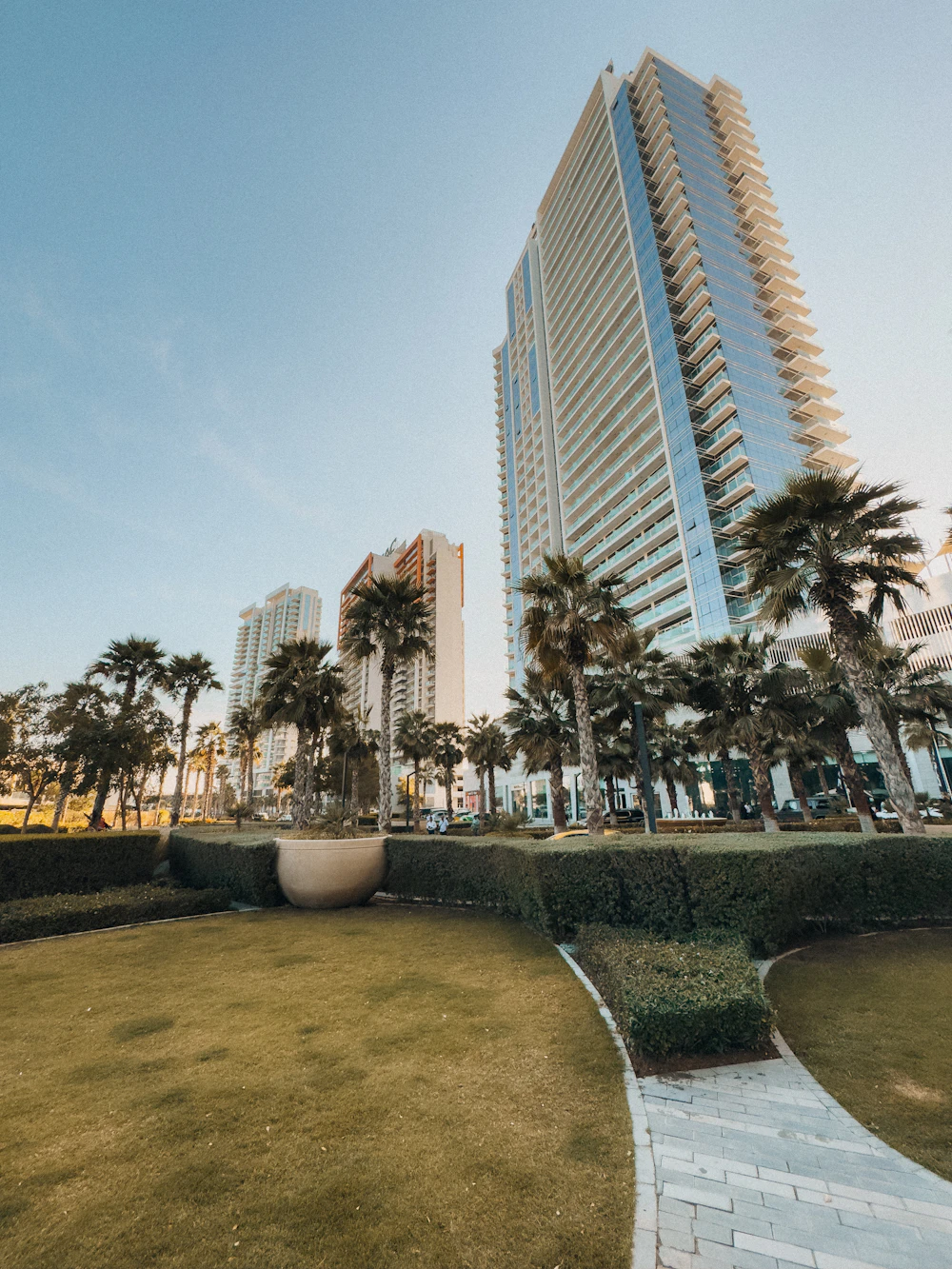 Apartment tower with palm trees and a landscaped lawn
