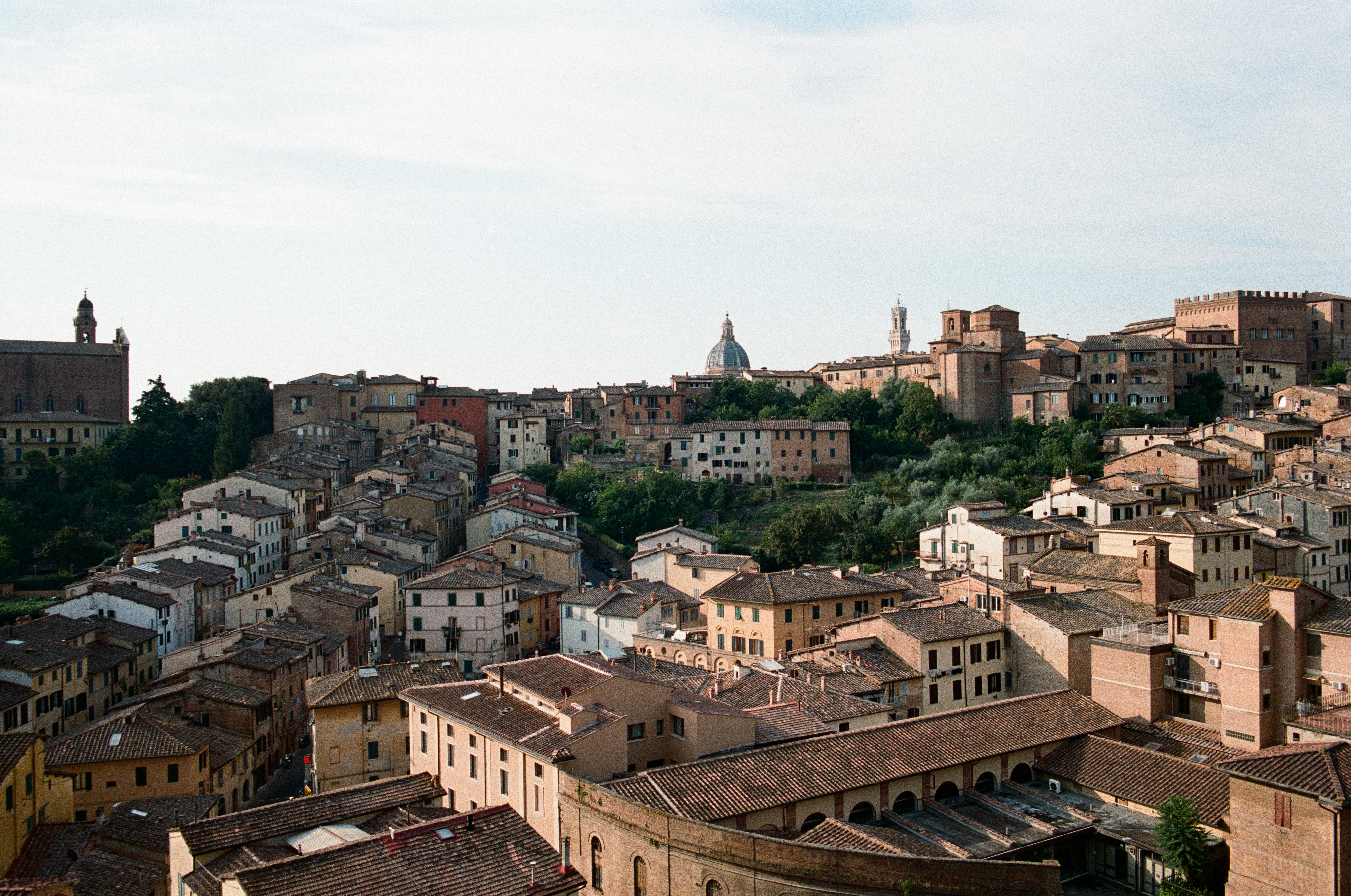 Terracotta rooftops on siena hillside with cathedral dome