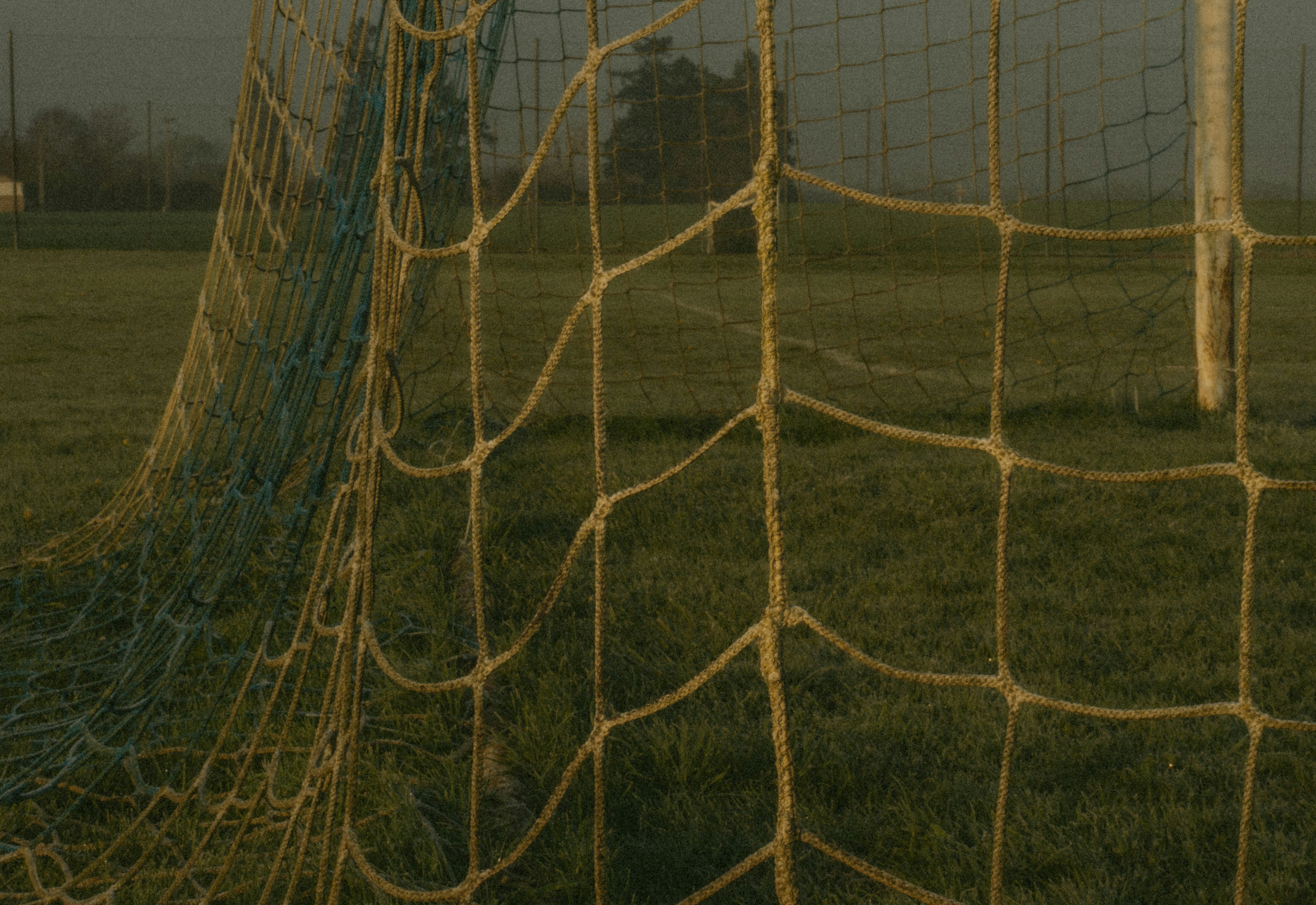 A soccer goal net on a green grassy field