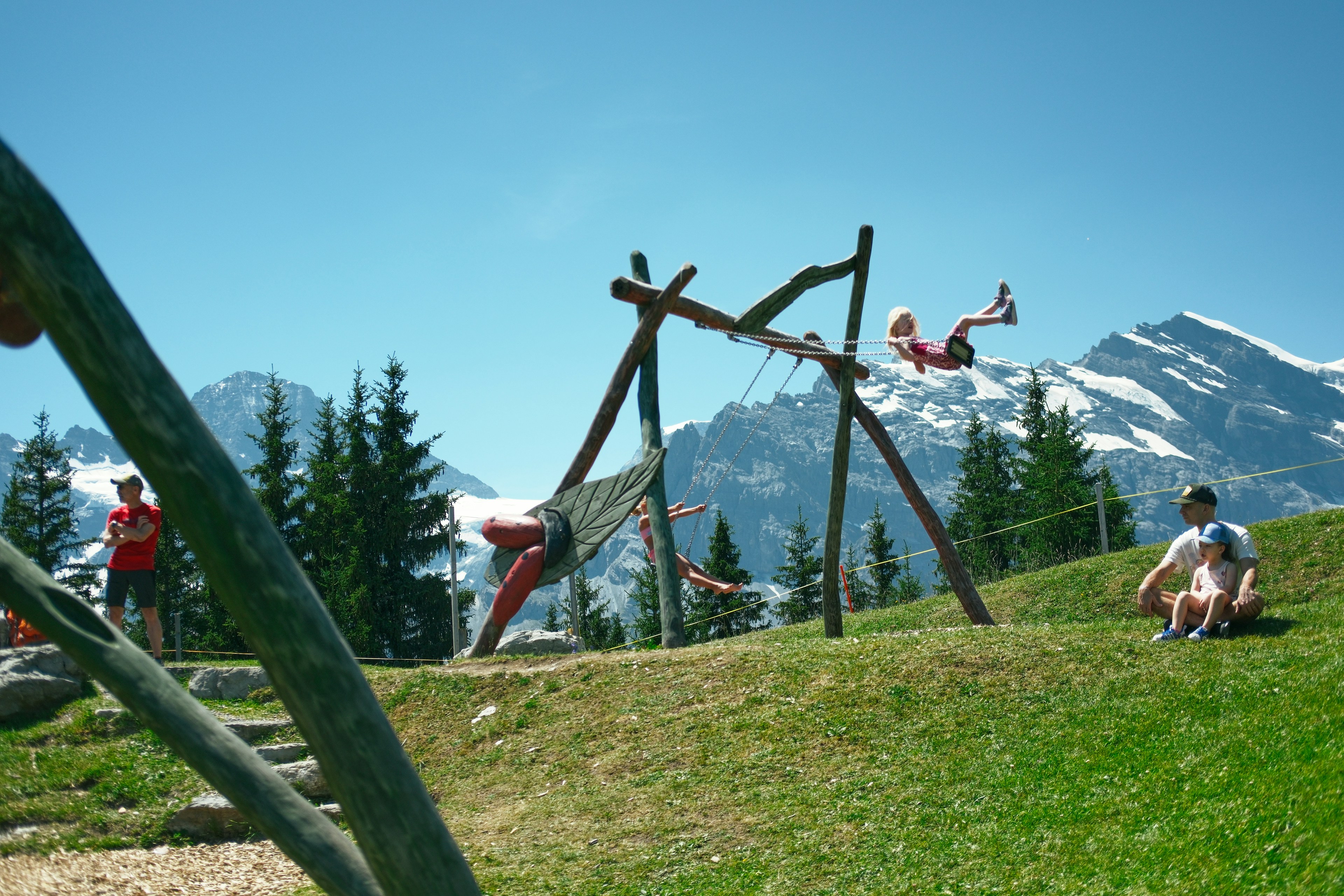 Children playing on swings in a mountain playground