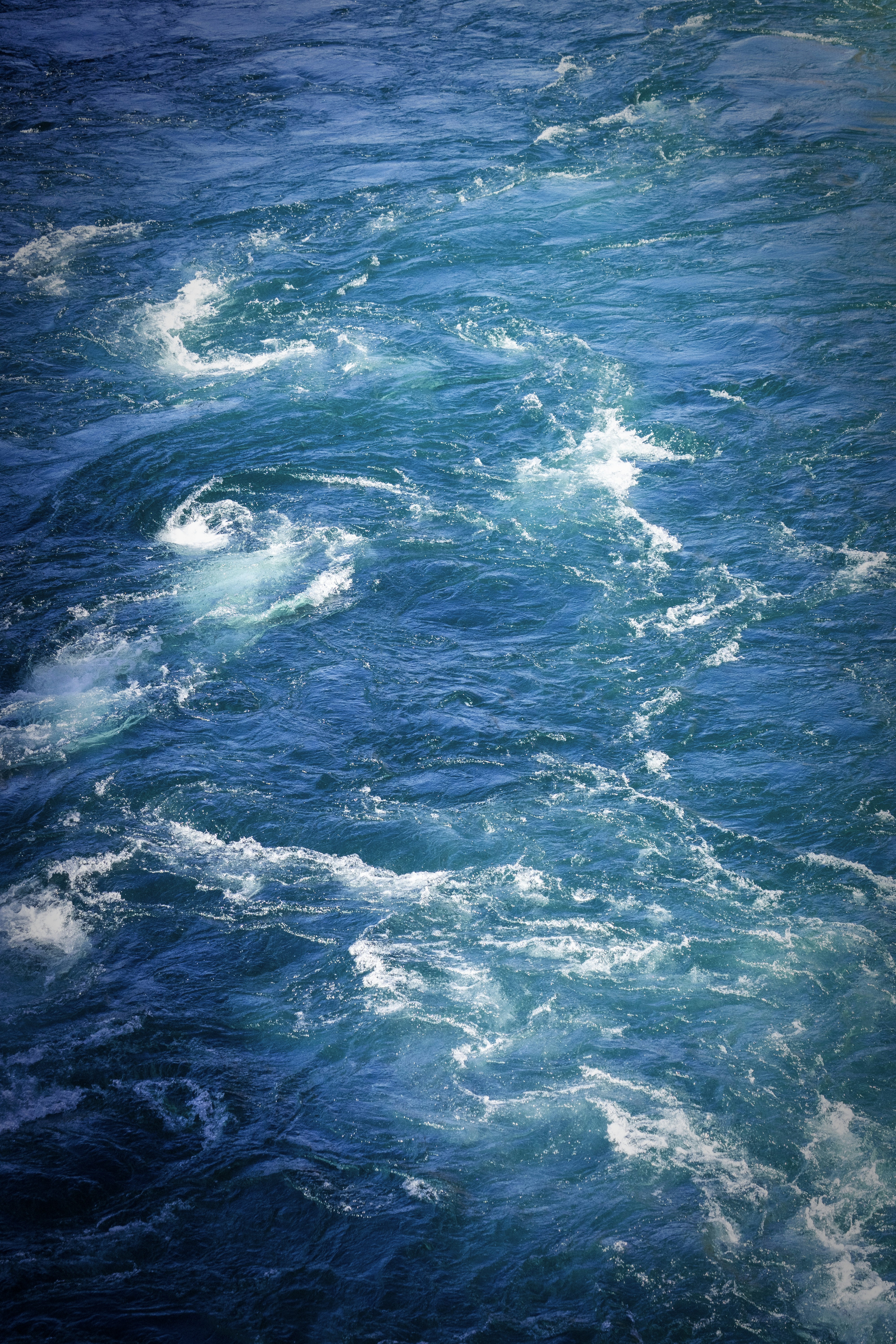 Swirling blue water with white foam.