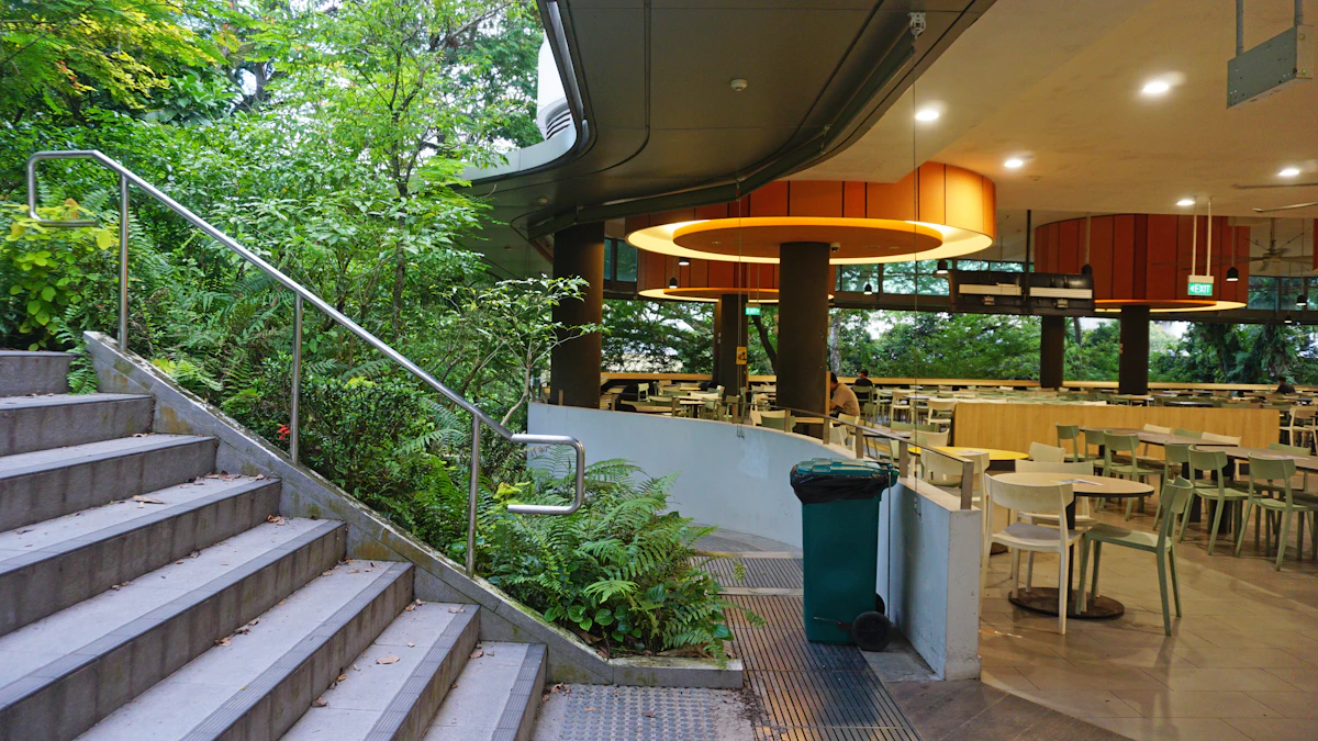 Modern dining area next to stairs and lush greenery