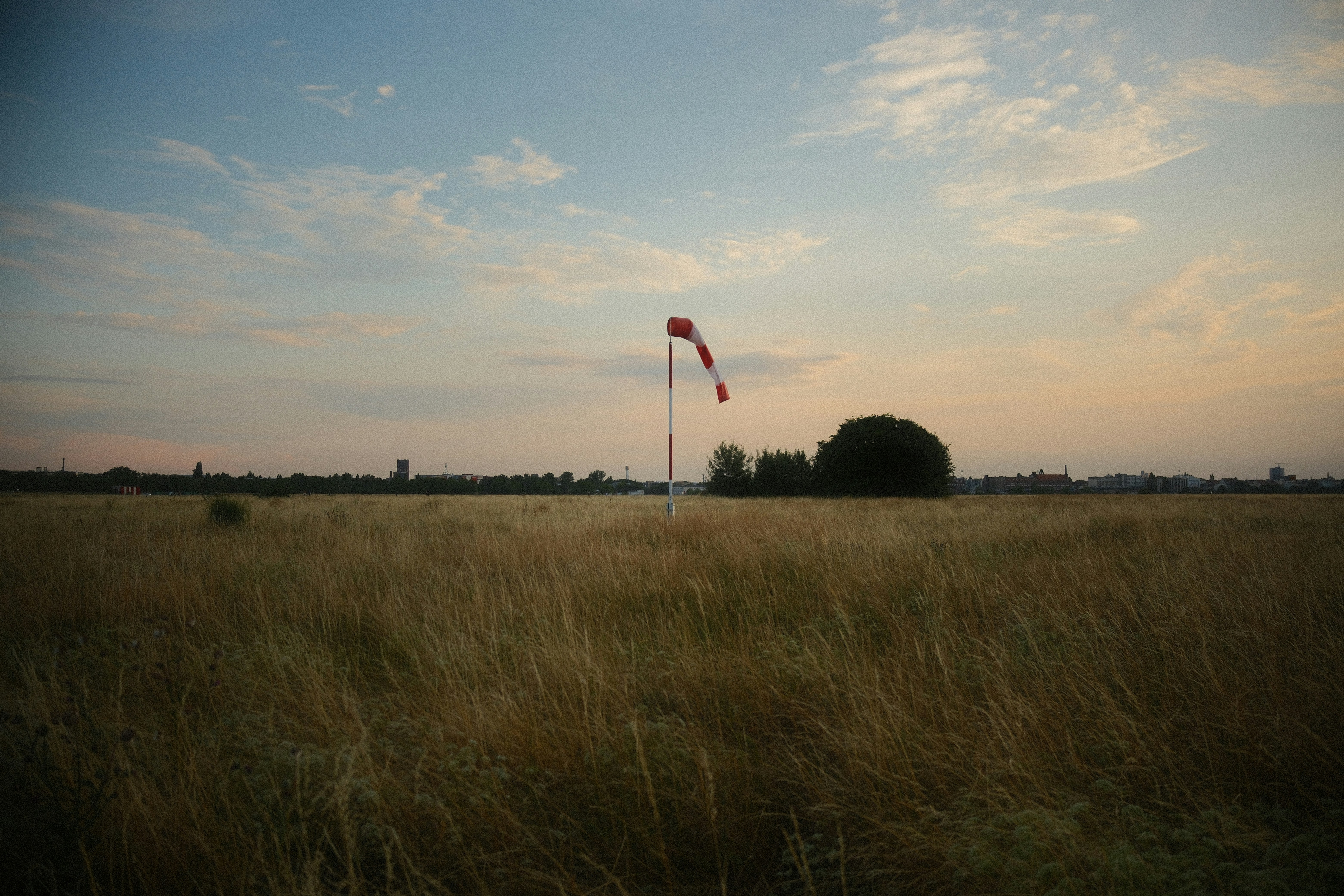 Red and white windsock in a field of golden grass.