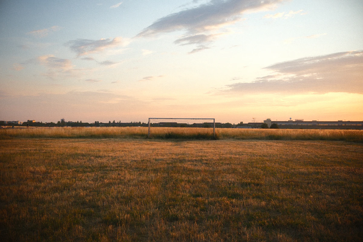 An empty football ground with a single goal at sunset