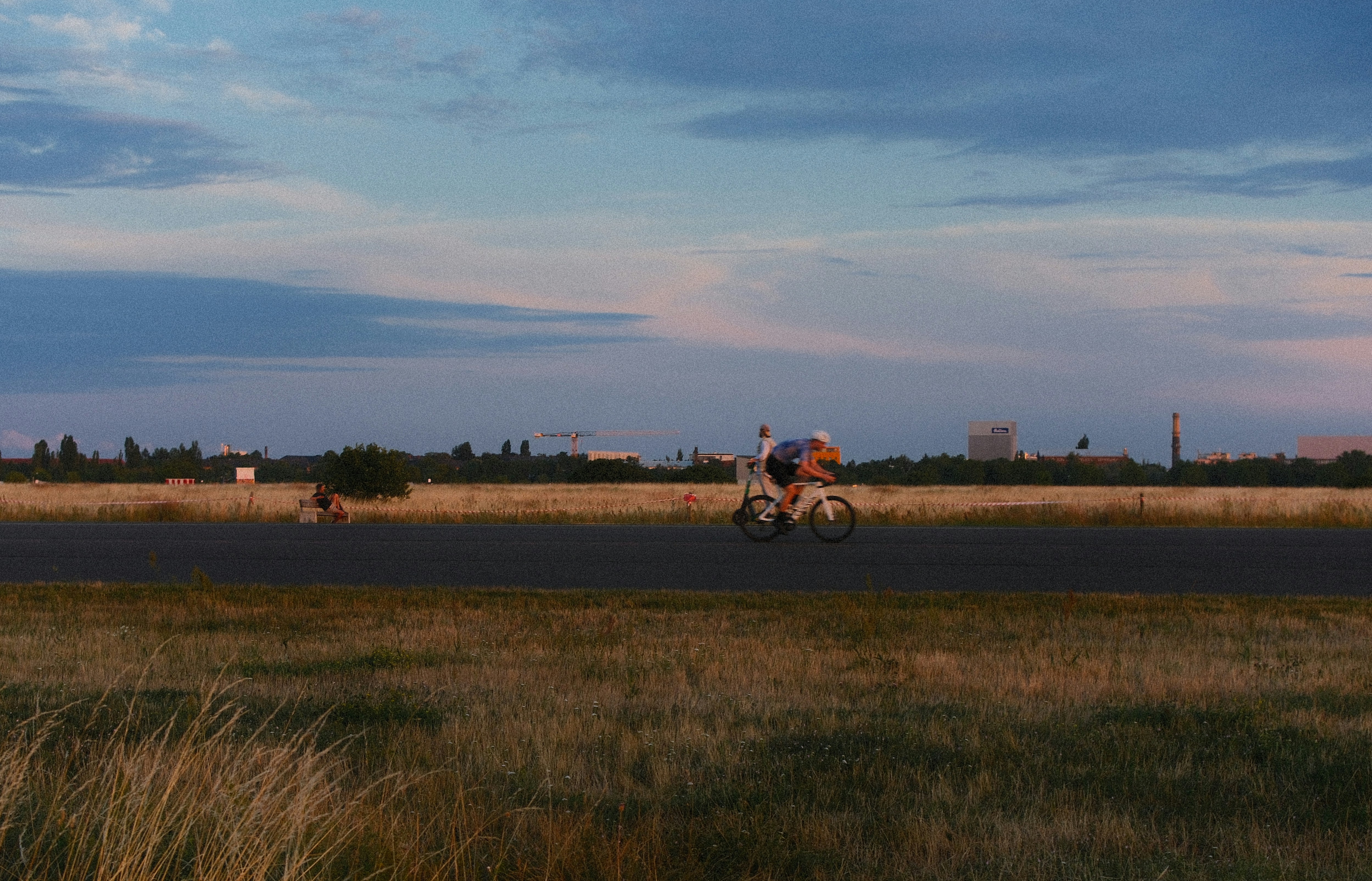 Two people on a path in a field at dusk