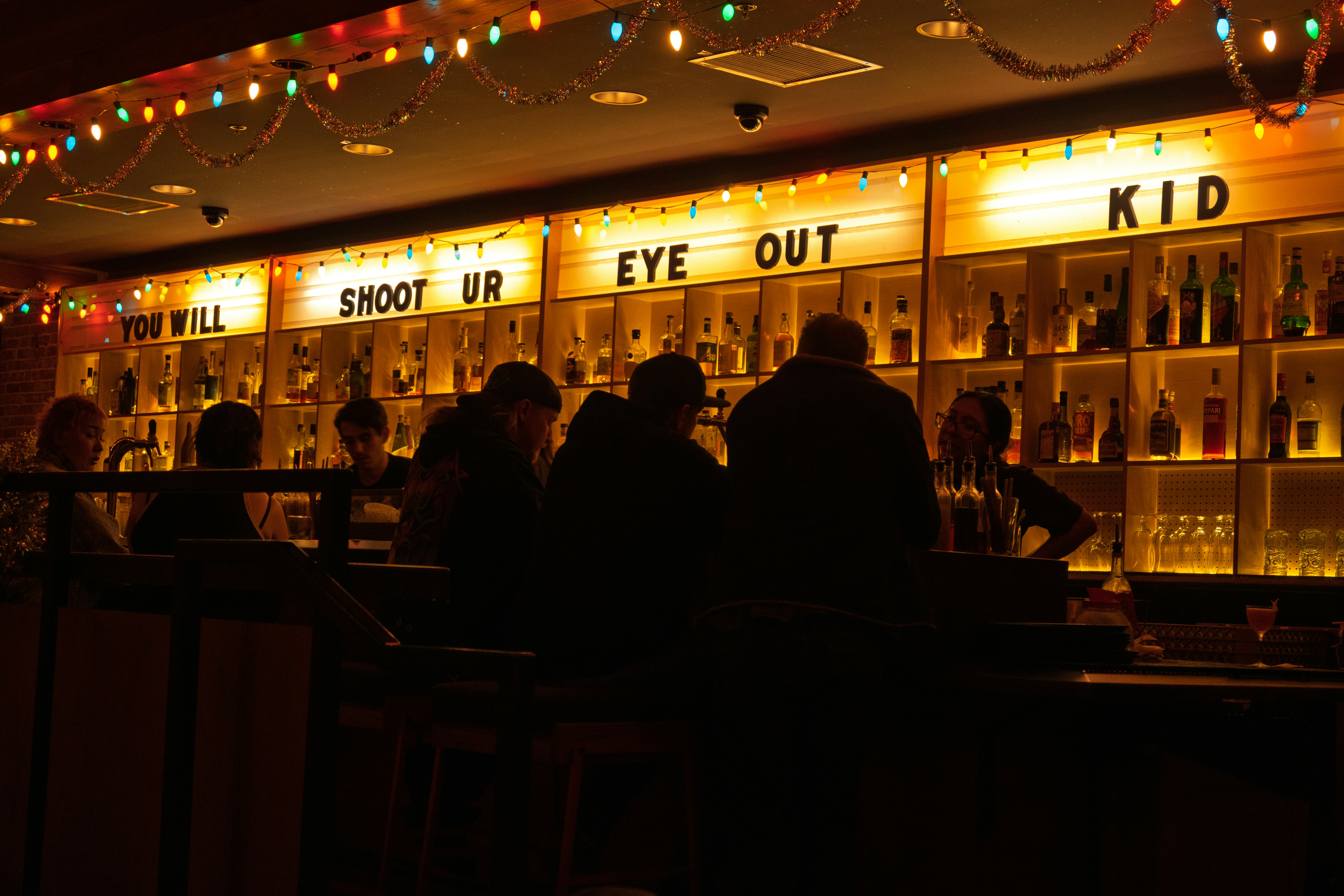 People sitting at a bar with illuminated signs
