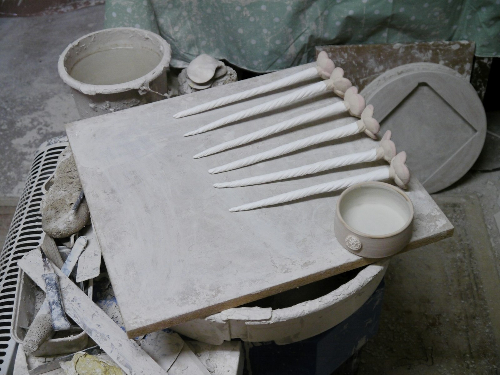 Des outils de céramique sur une planche poussiéreuse