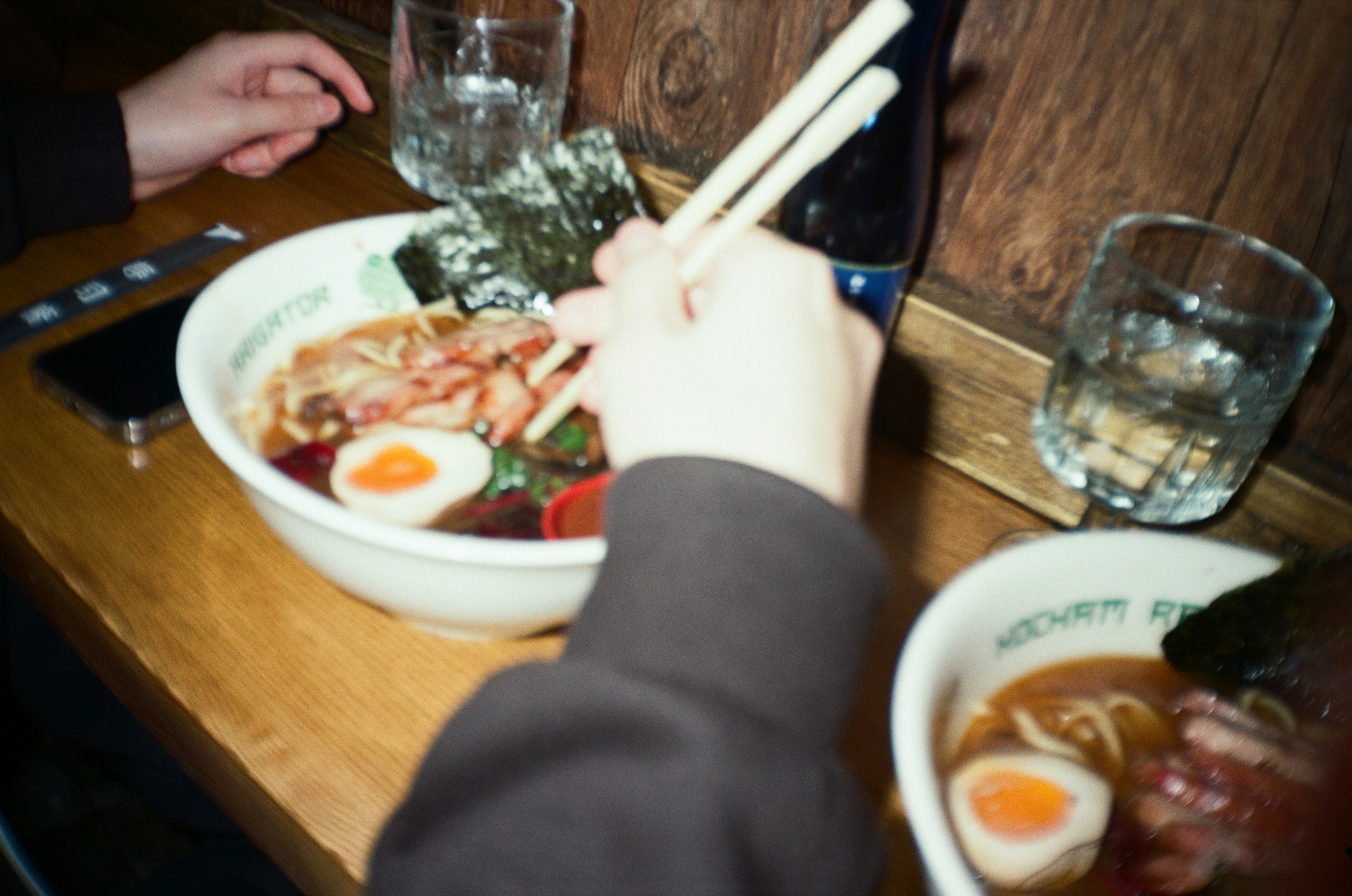 Hands eating ramen