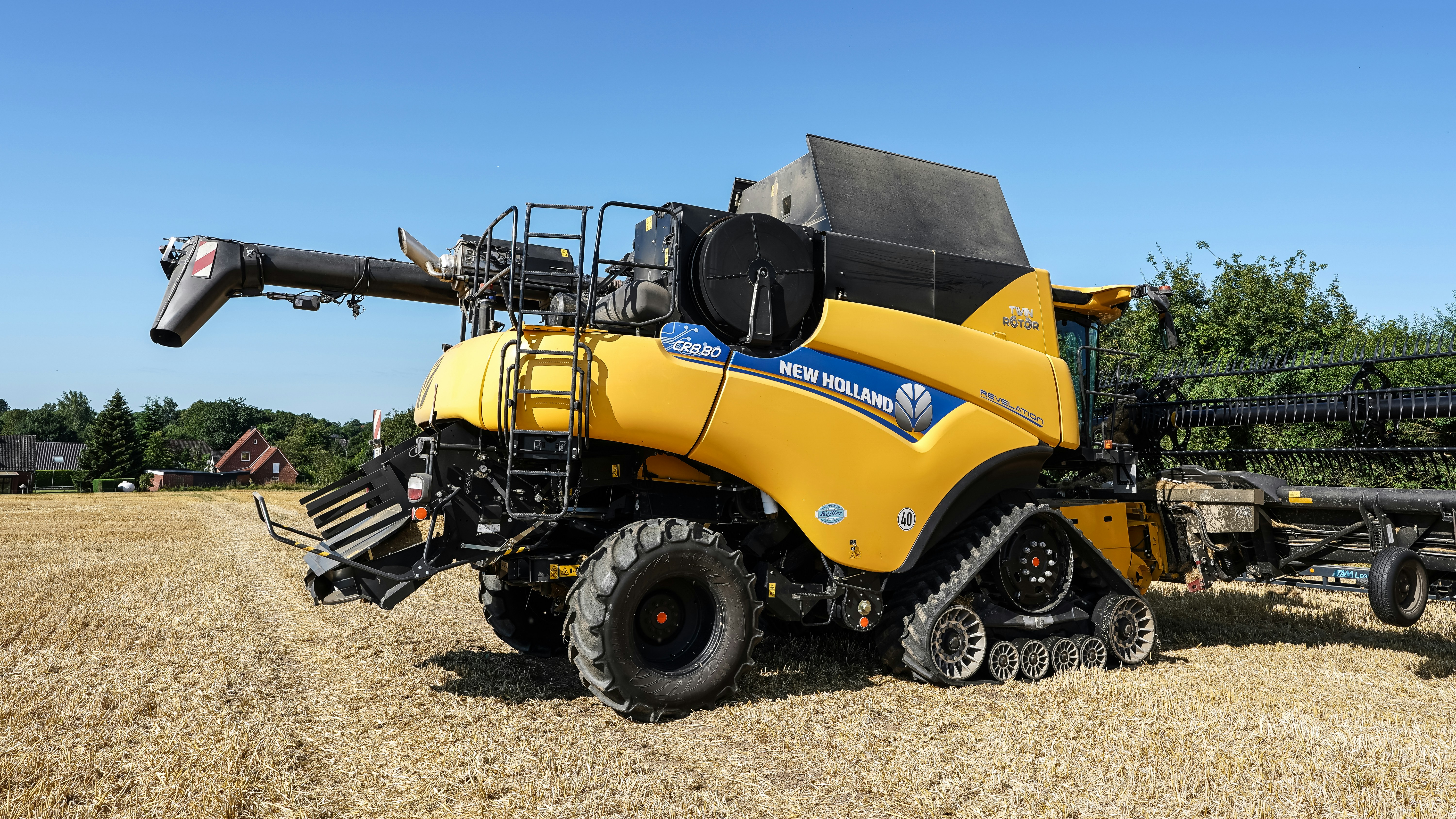 Uma ceifeira amarela New Holland em um campo.