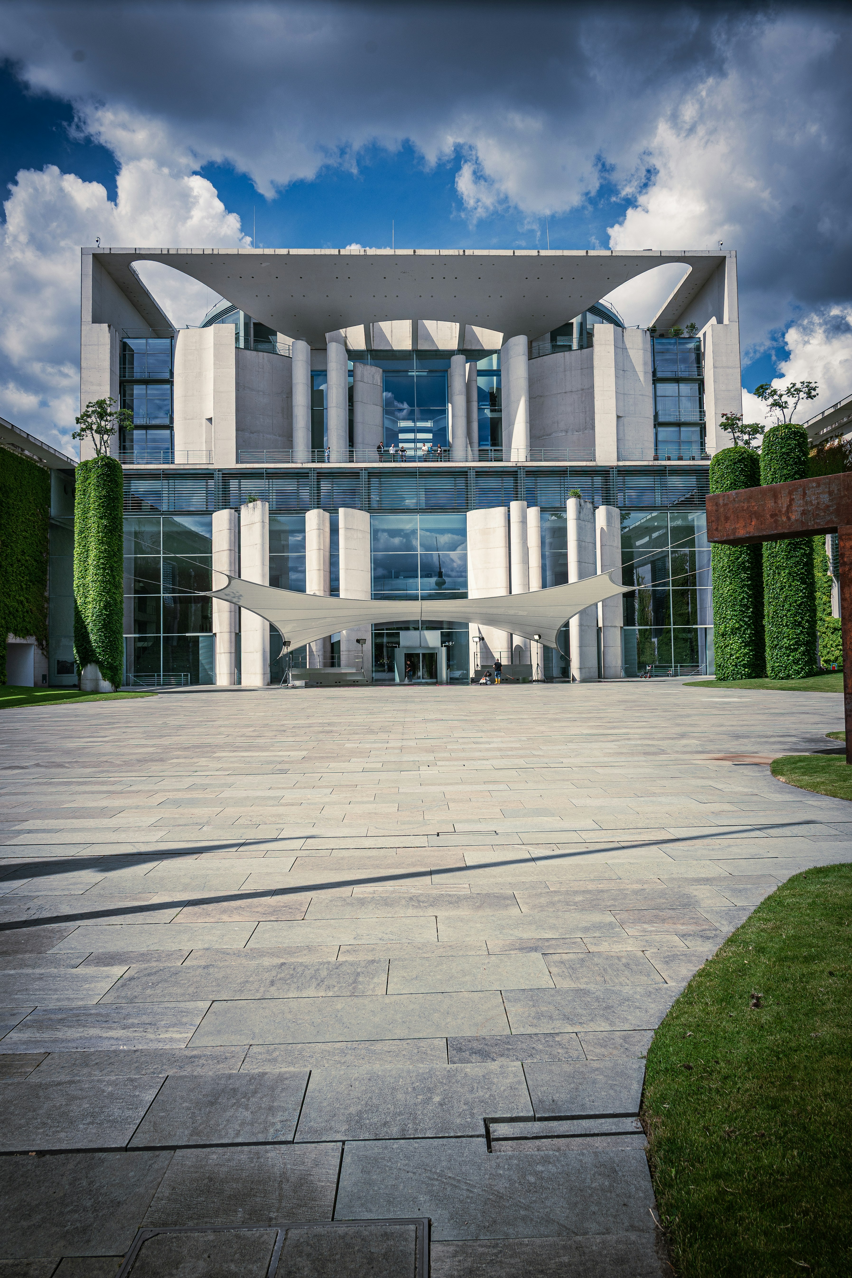 Contemporary building with glass facade and paved courtyard.
