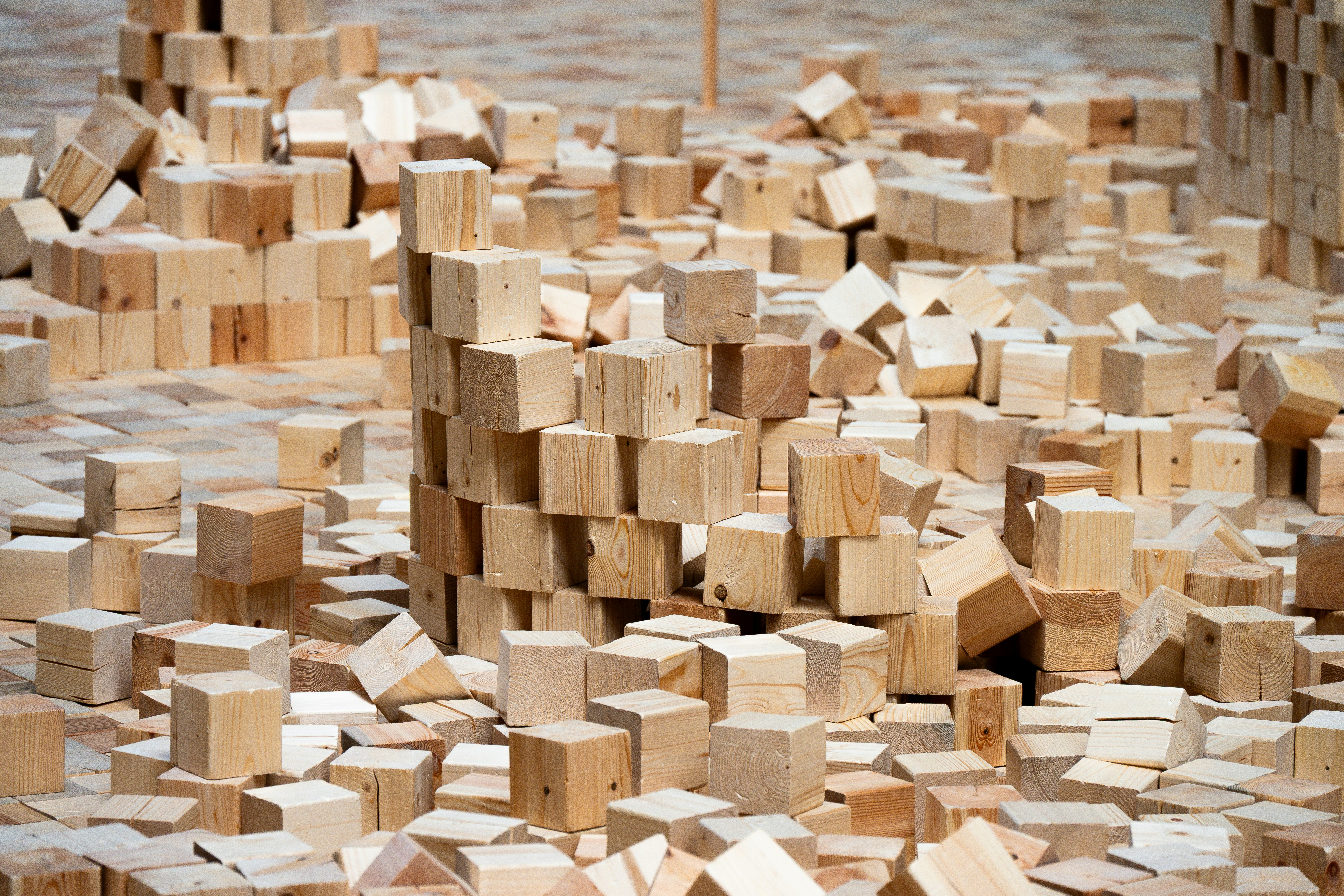 Numerous small wooden blocks scattered and stacked on a surface
