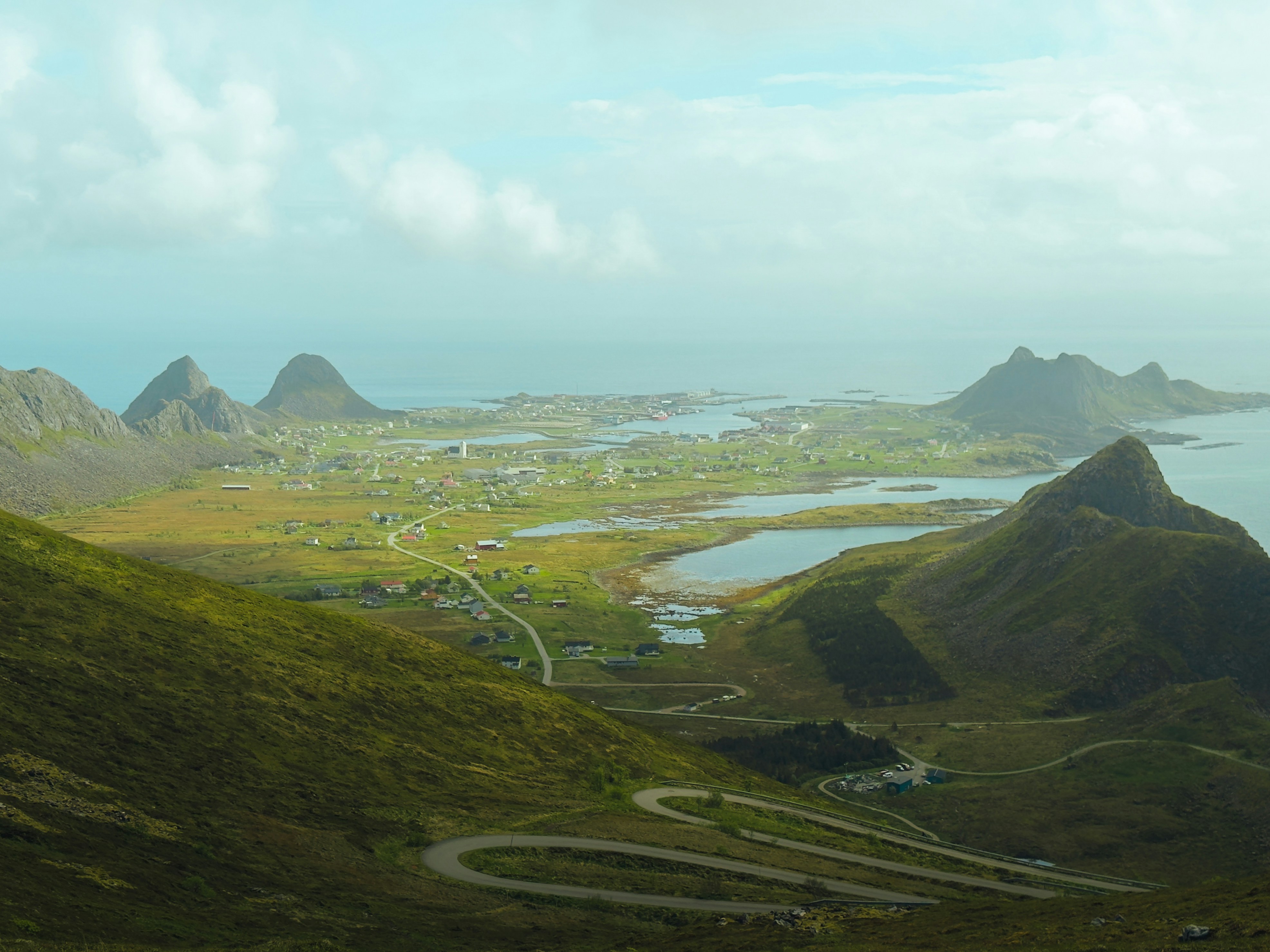 Winding road descends to a coastal town nestled among mountains