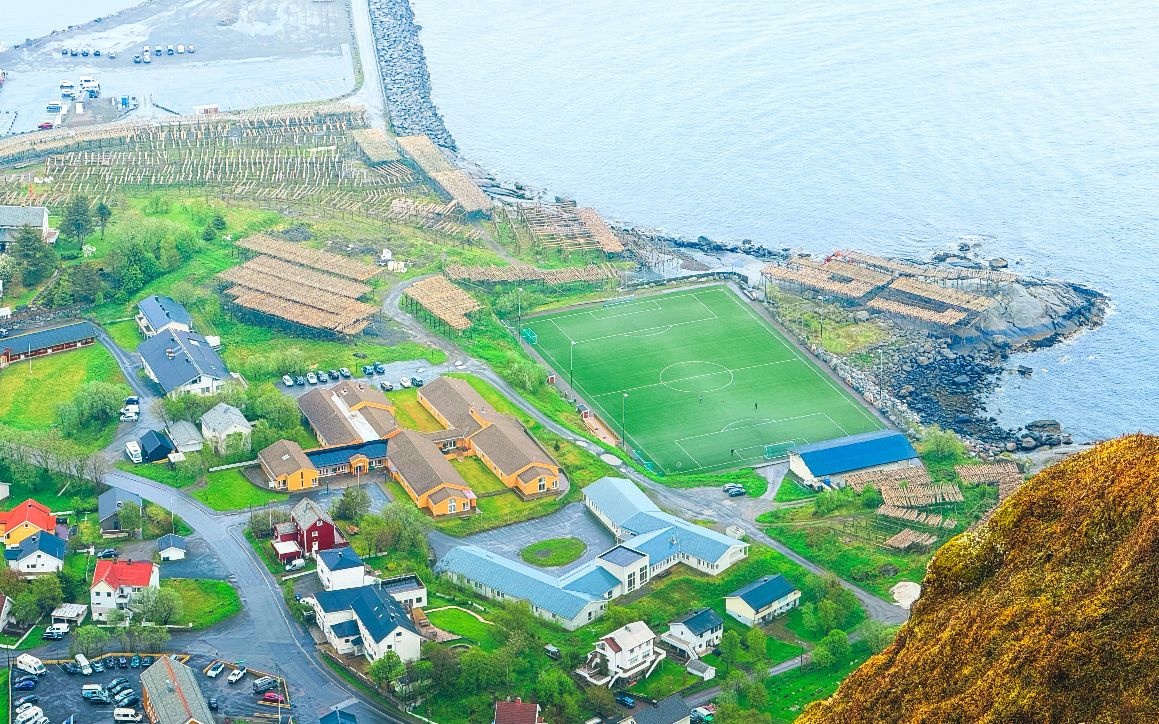 Coastal town with buildings, a soccer field, and ocean