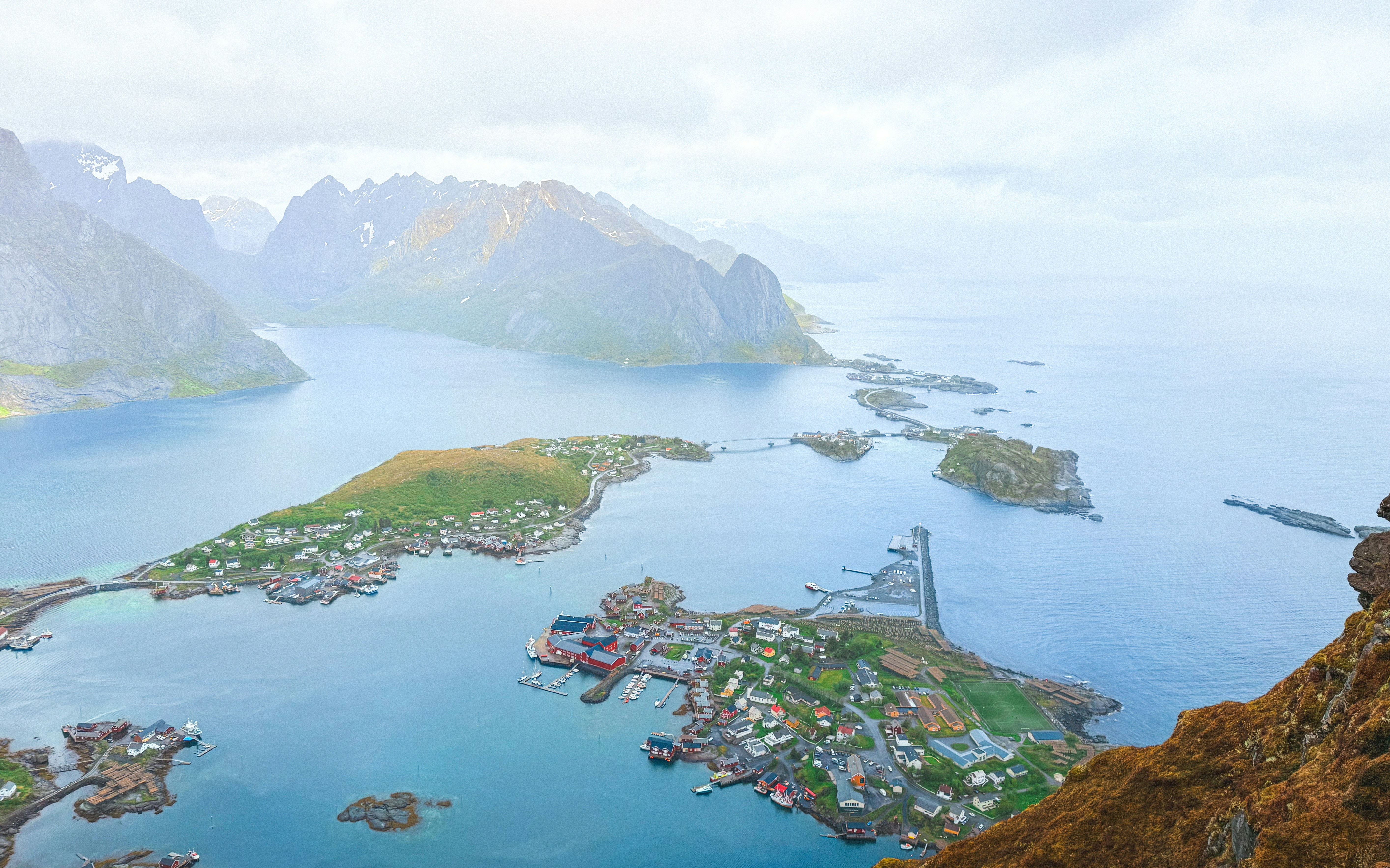 Panoramic view of a coastal village with islands and mountains