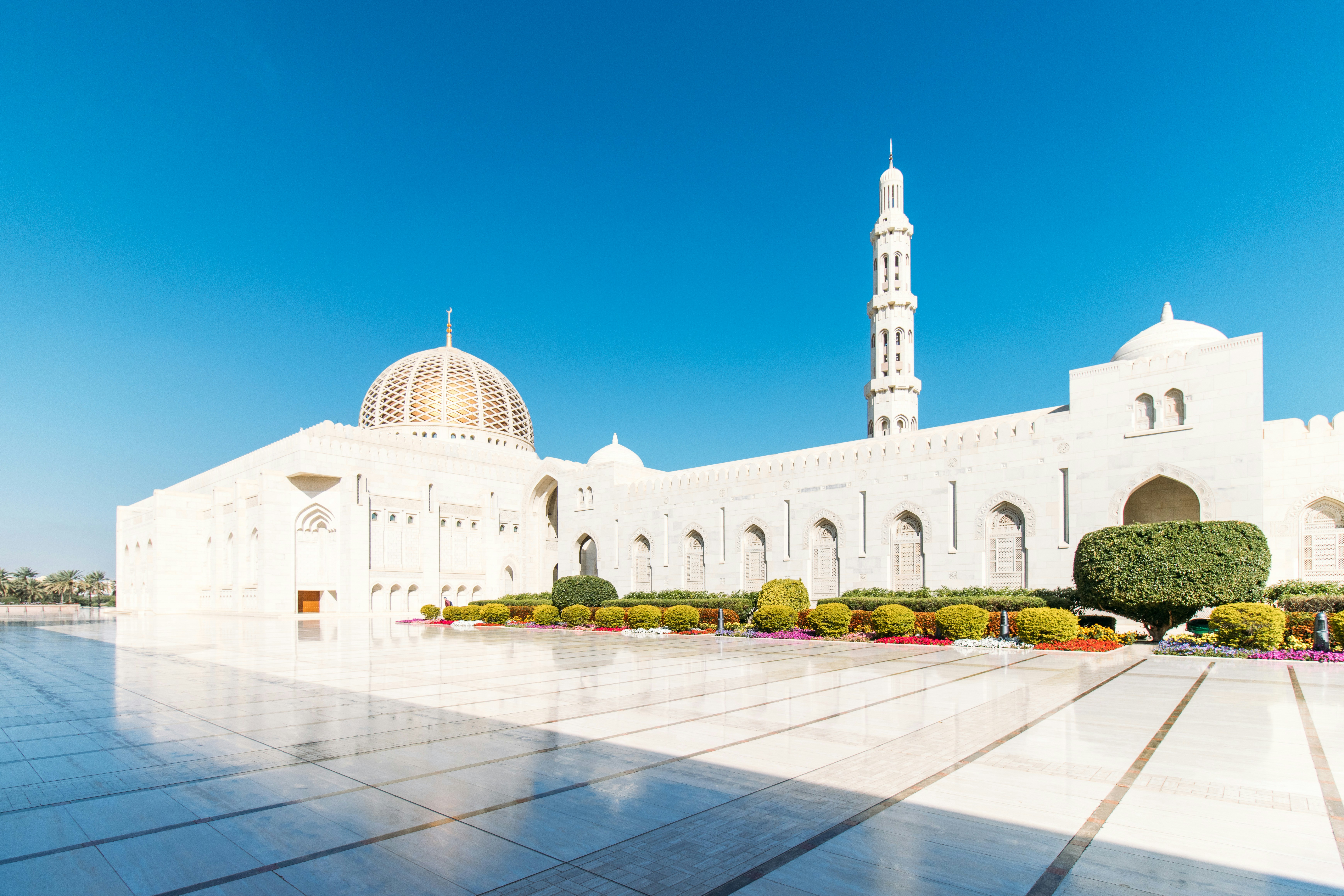 Mezquita y minarete blancos majestuosos bajo un cielo azul despejado