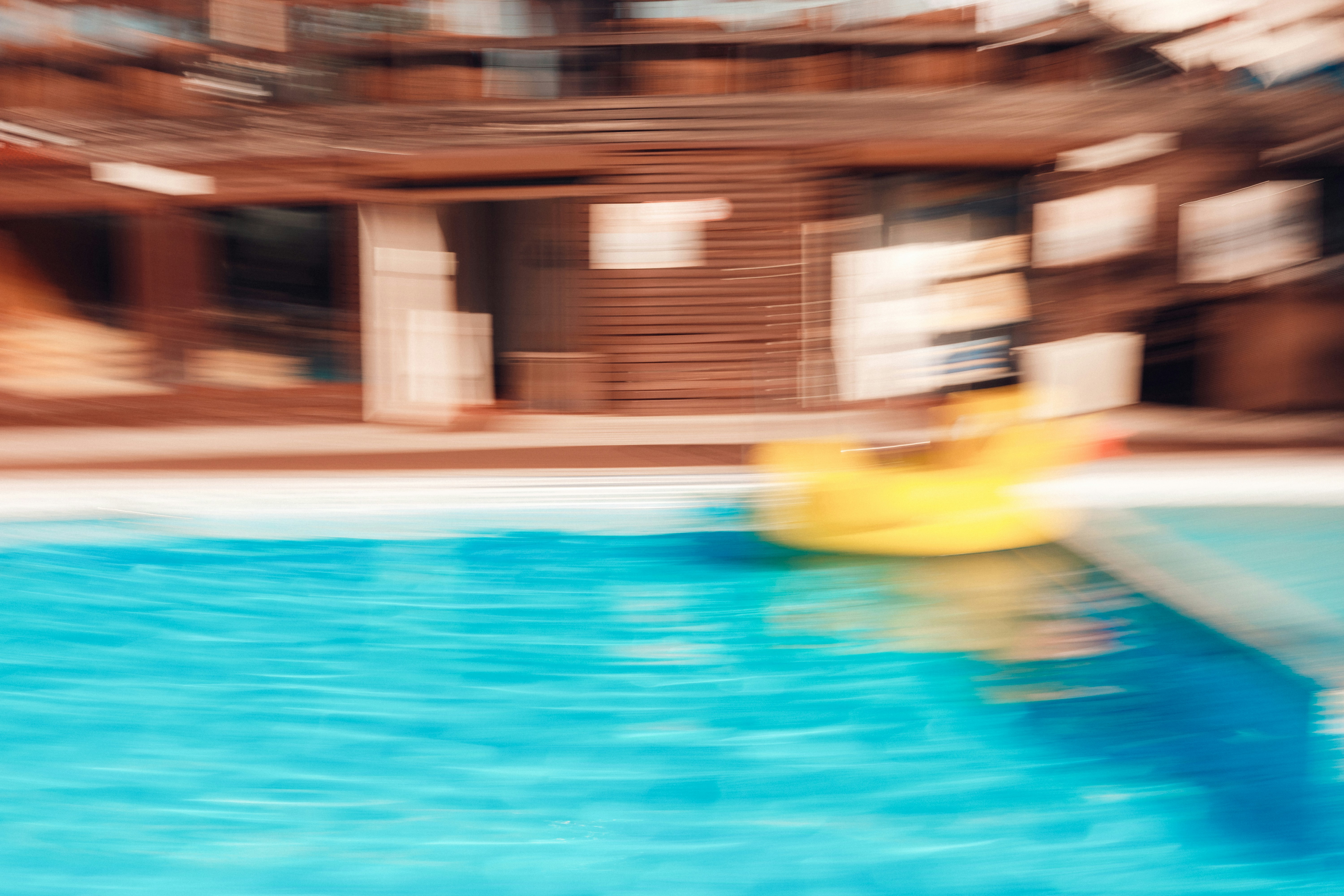Yellow inflatable ring in a motion-blurred swimming pool.