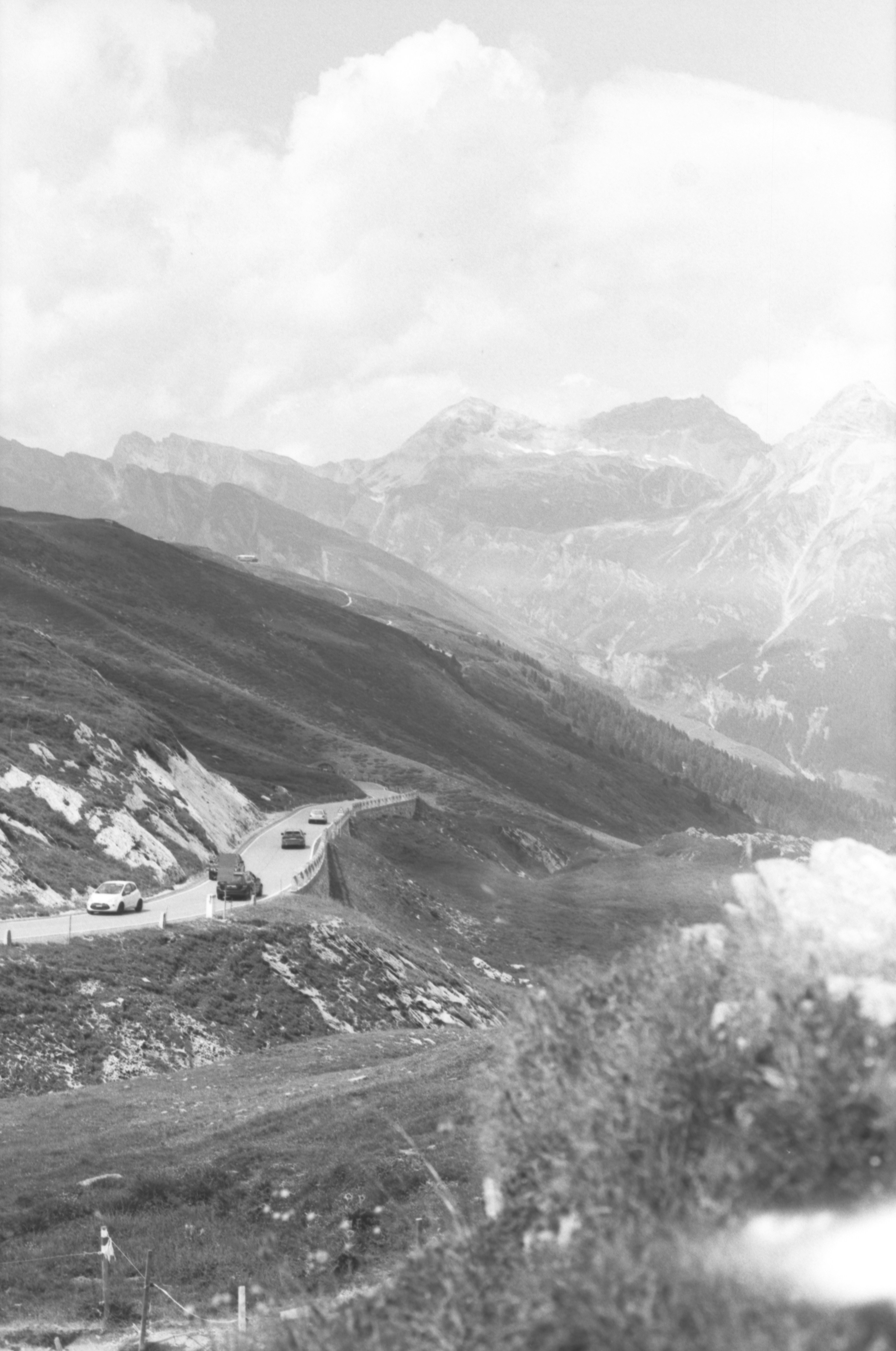 Auto bianche e nere su una strada di montagna tortuosa.