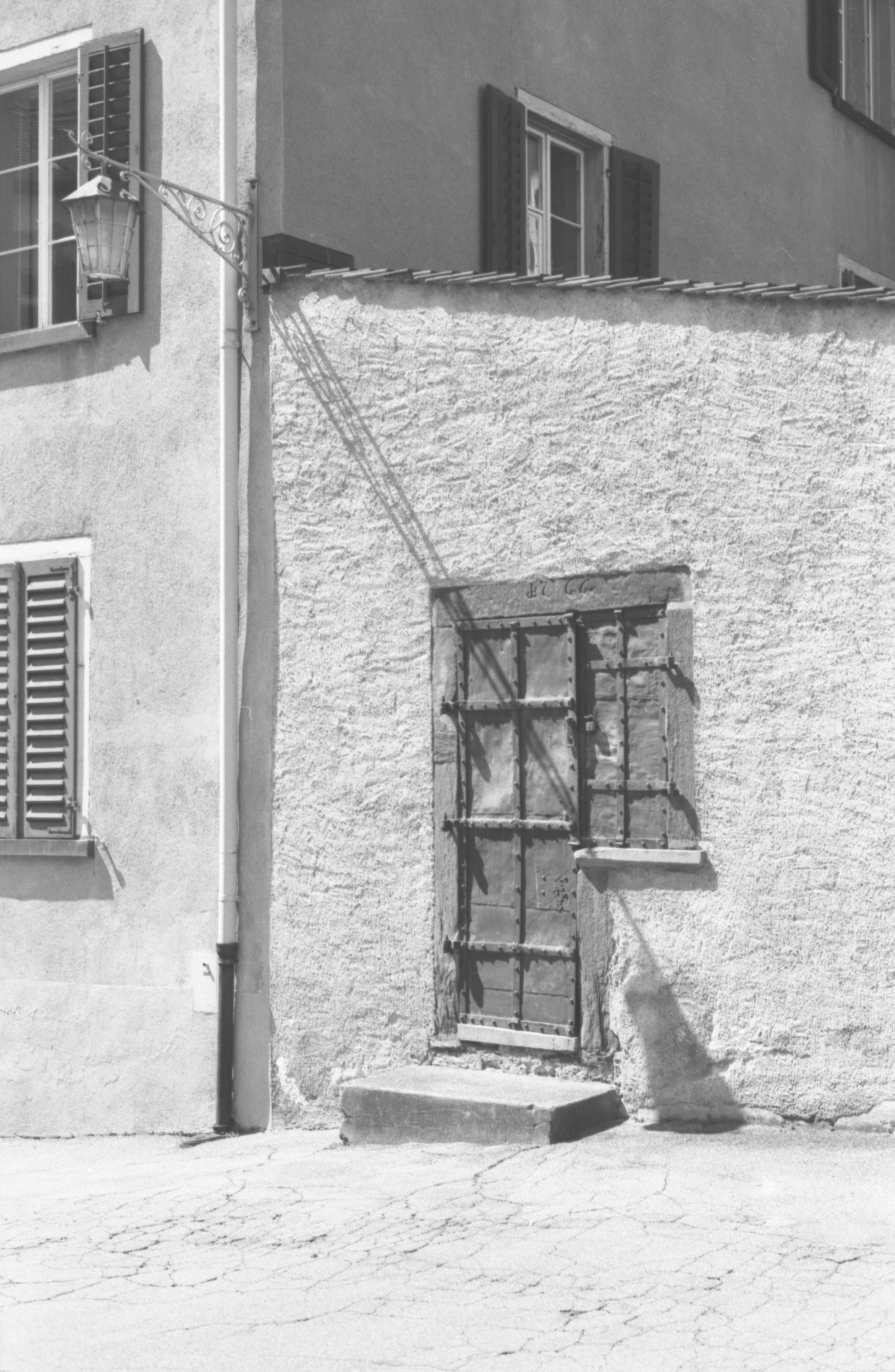 Angolo edificio storico con porta scura e parete testurizzata.