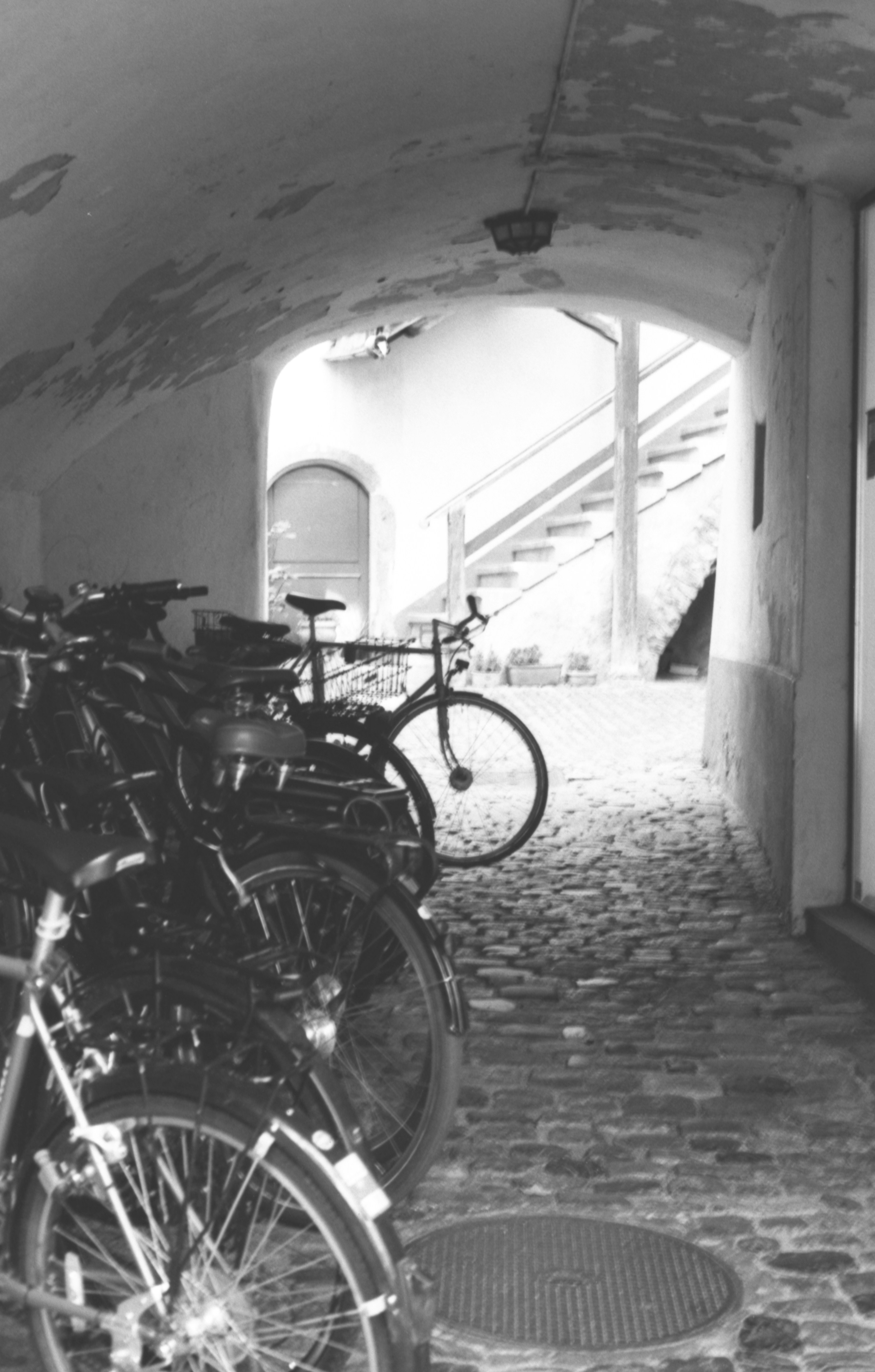 Biciclette parcheggiate in un arco di ciottoli che conduceva alle scale.