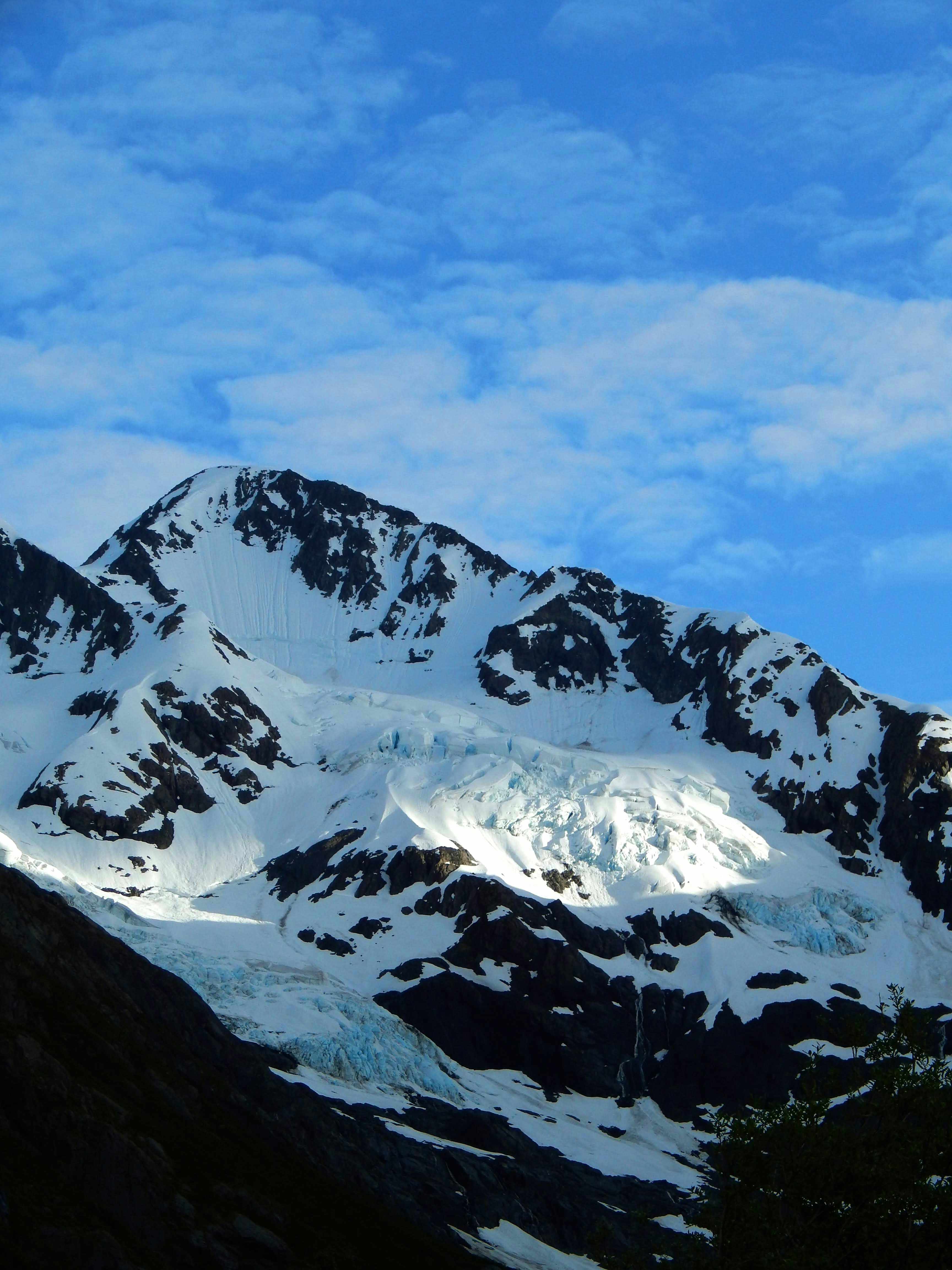 Glacier on a snow-covered mountain under a blue sky.