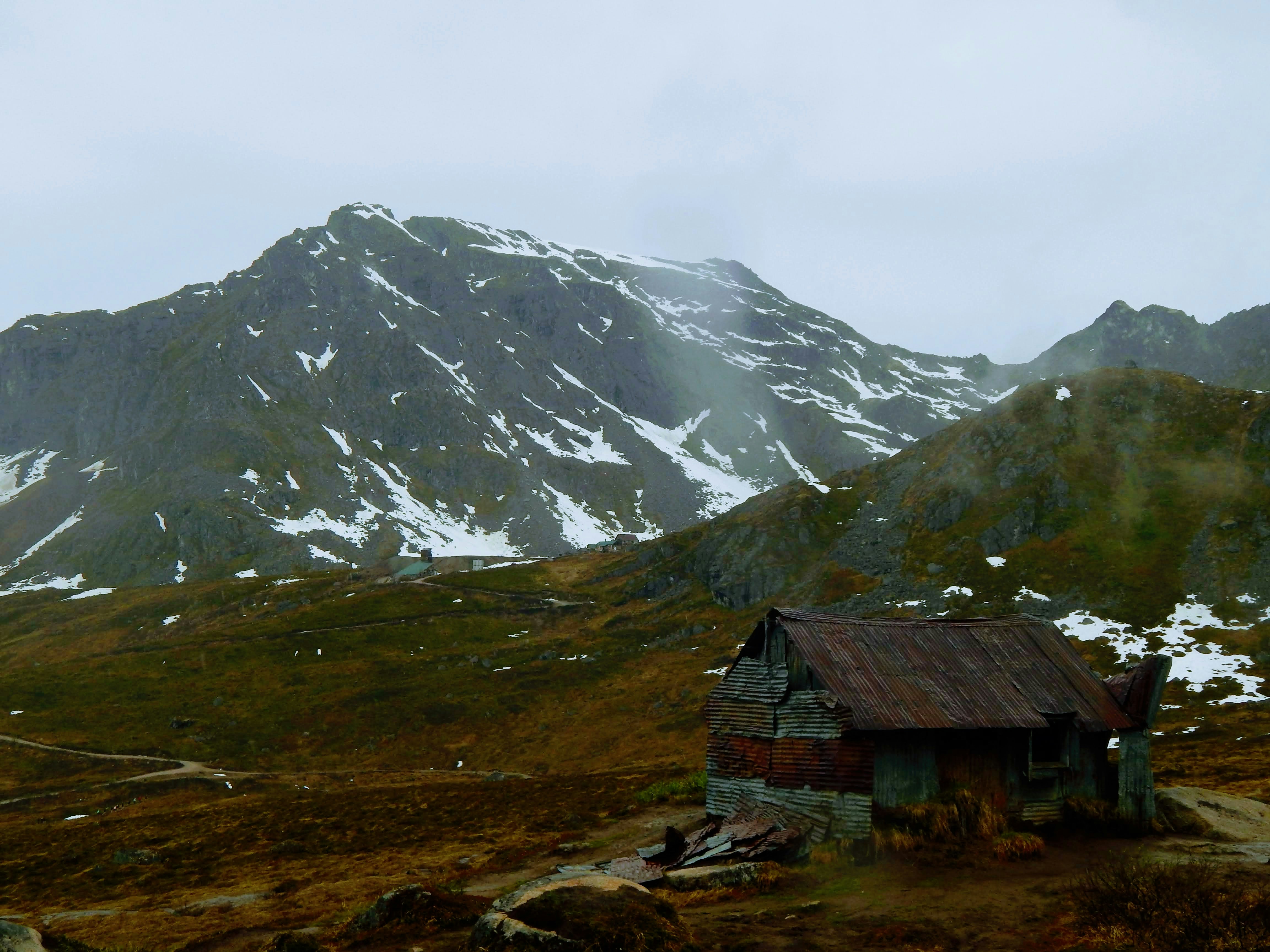 An old cabin in a snowy mountain landscape.