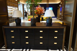 Elegant black dresser with two lamps and a floral arrangement