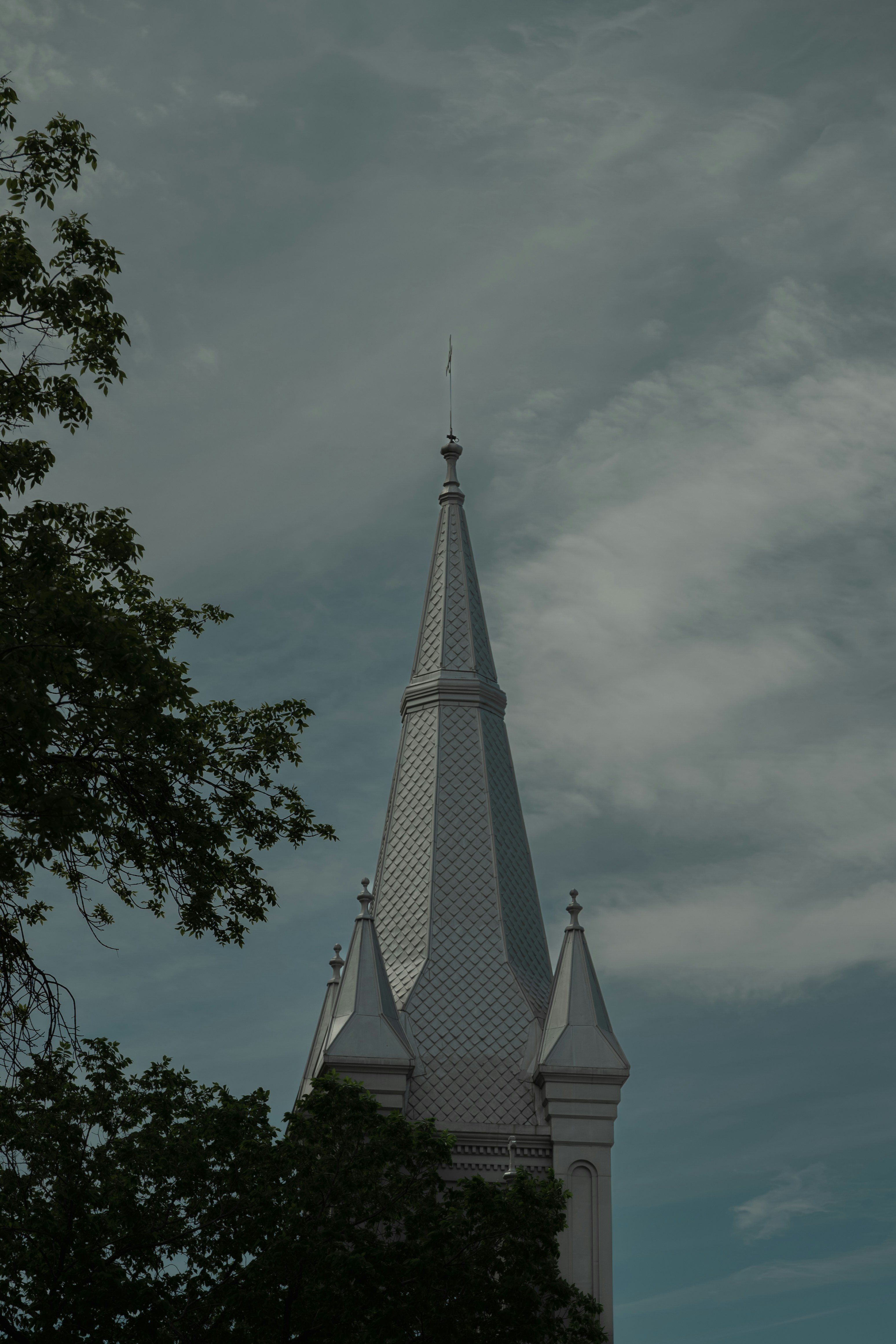 A tall church spire against a cloudy sky