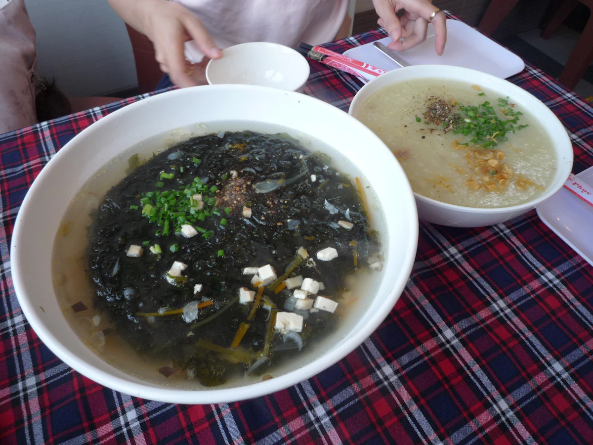 Súp rong biển Hàn Quốc miyeok-guk dọn cùng cháo trên bàn trải khăn kẻ caro