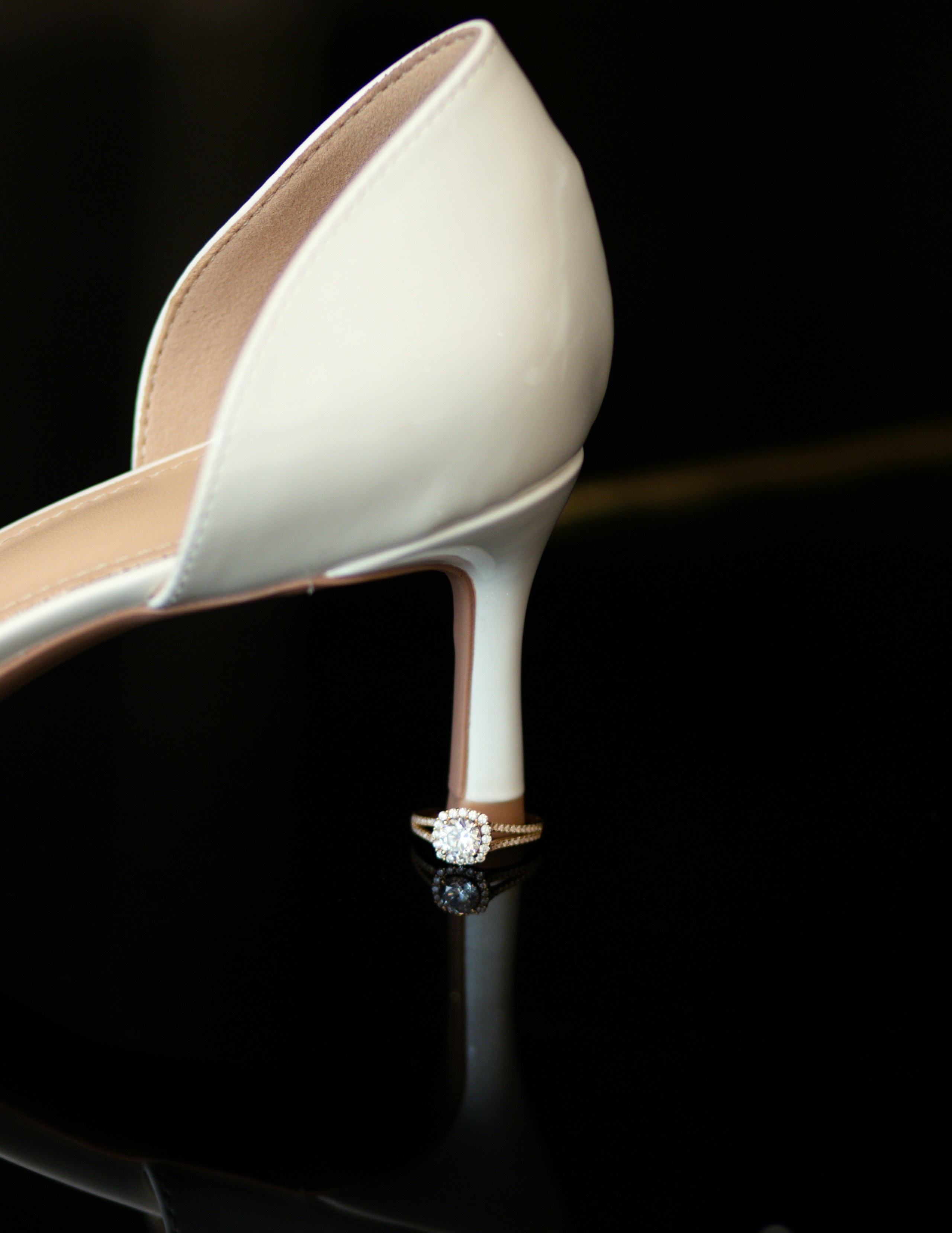 Chaussure blanche à talons hauts avec une bague en diamant.