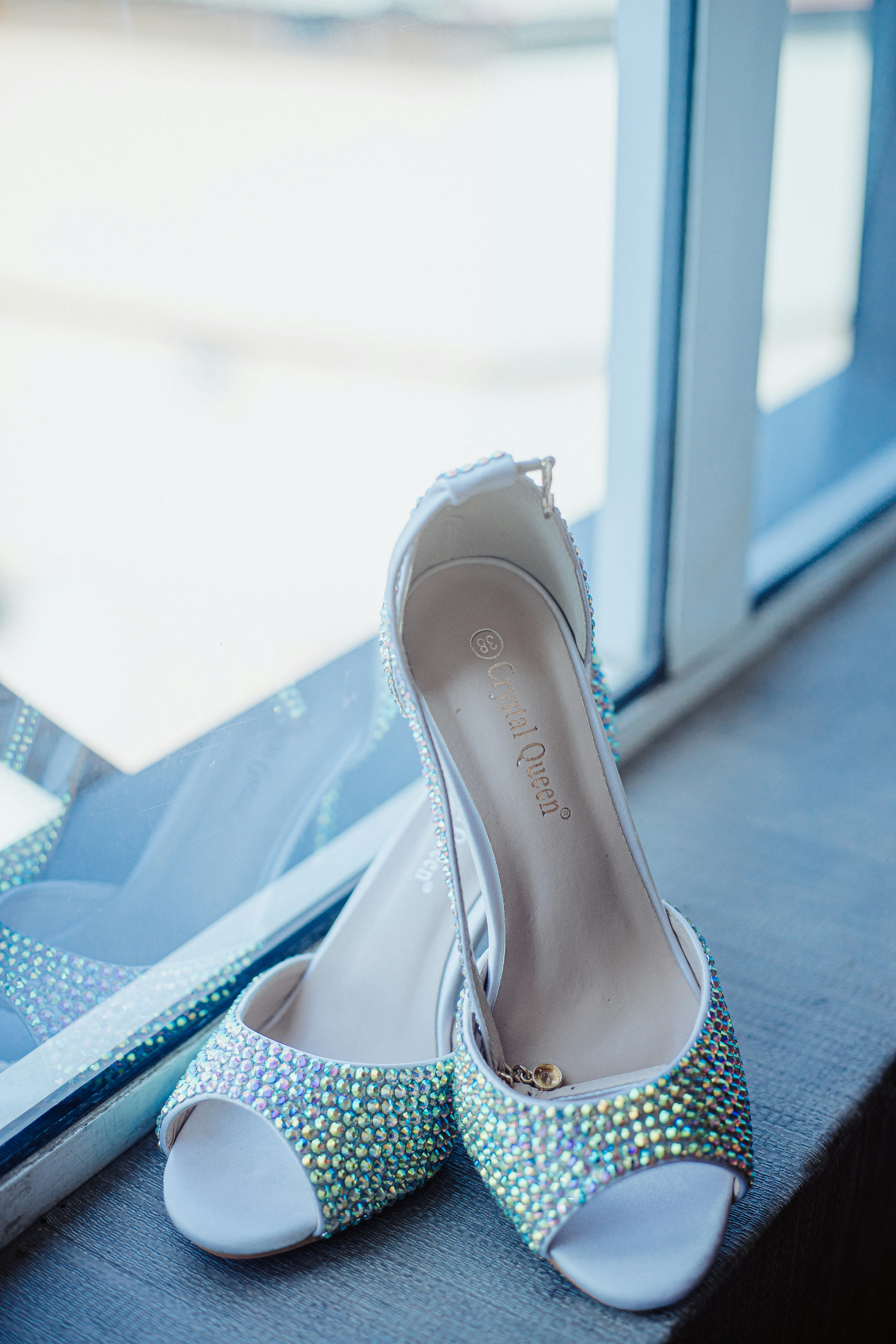 Elegant white rhinestone shoes with a ring by the window