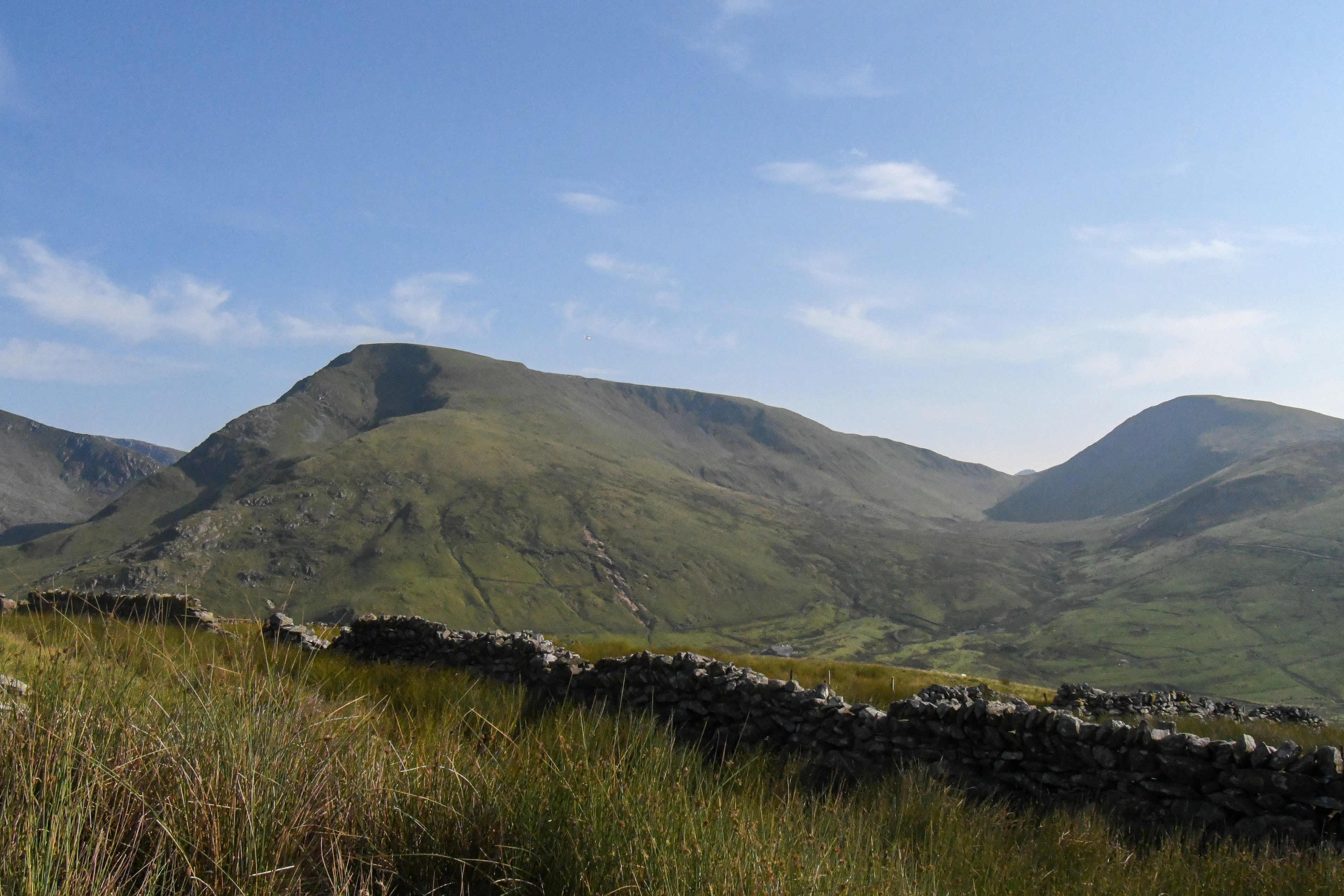 Rolling green mountains and a stone wall near Yr Wyddfa