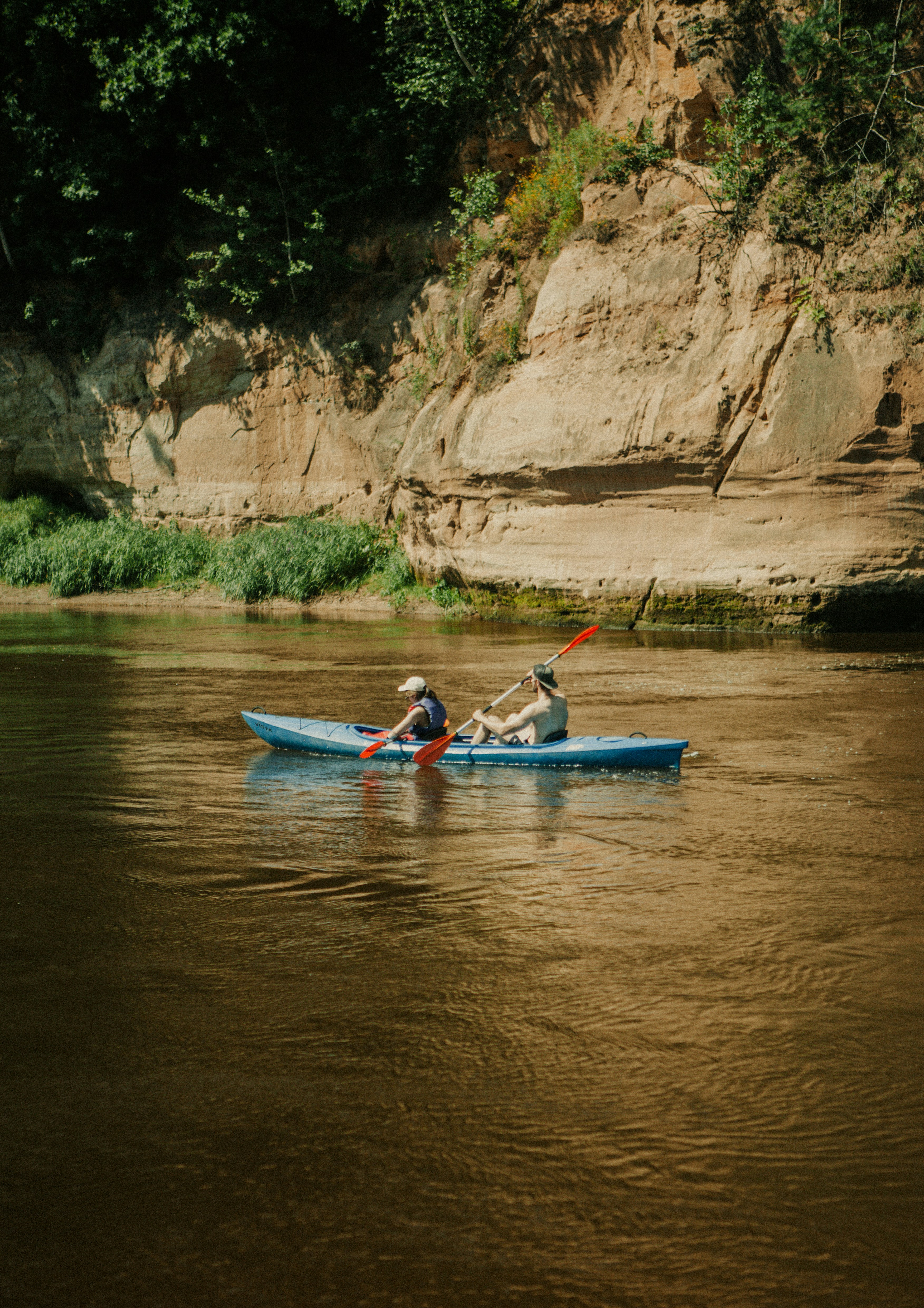 People kayaking between rocky cliffs