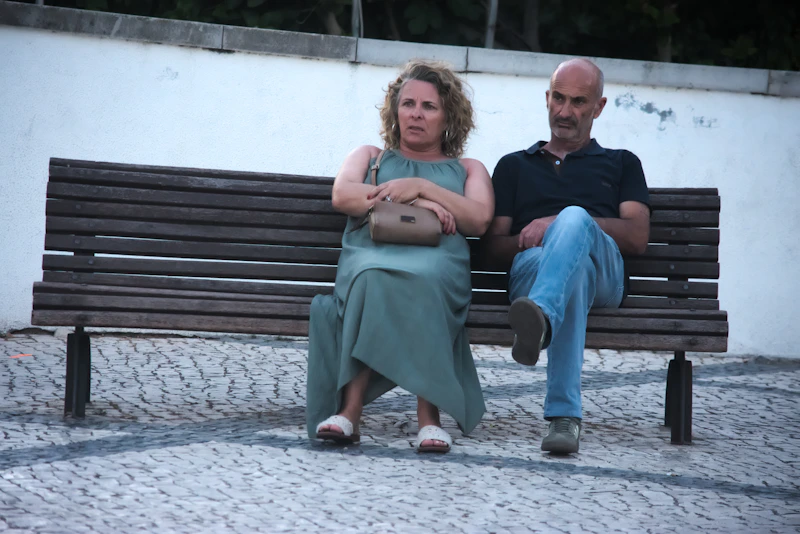 mature couple sitting thoughtfully on a park bench