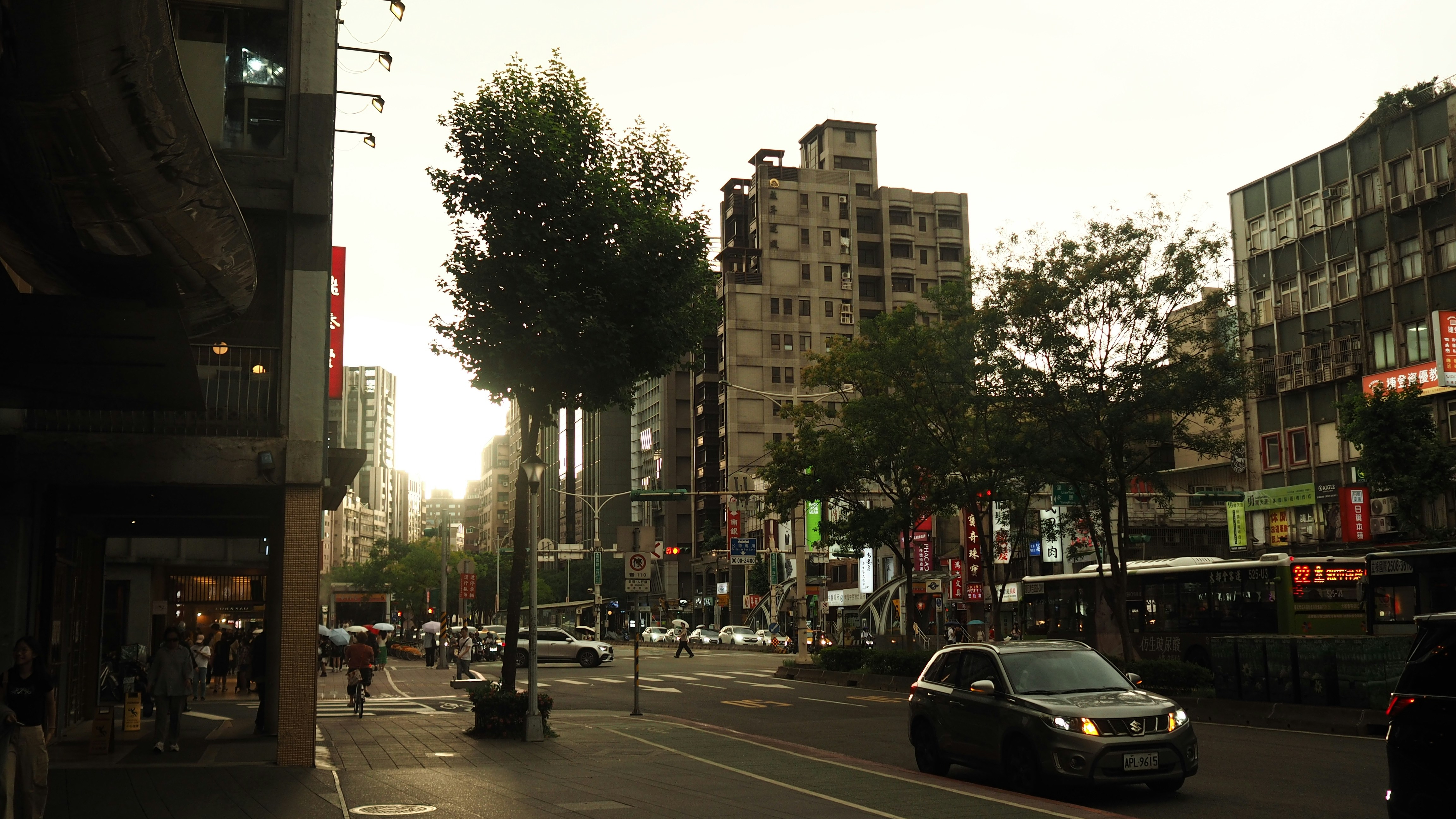Busy city street with cars, buildings, and people.