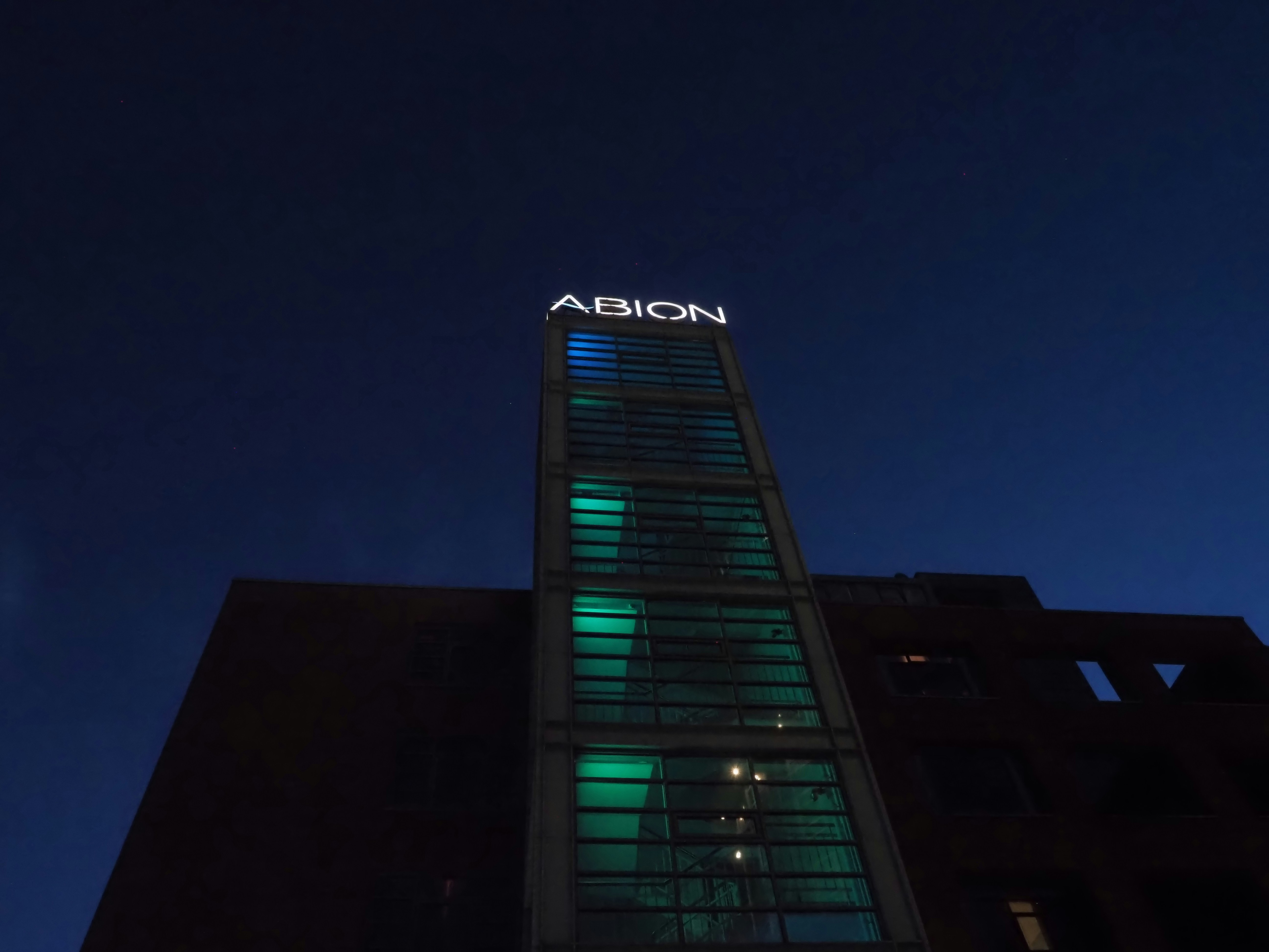 Abion building lit up against a dark blue sky