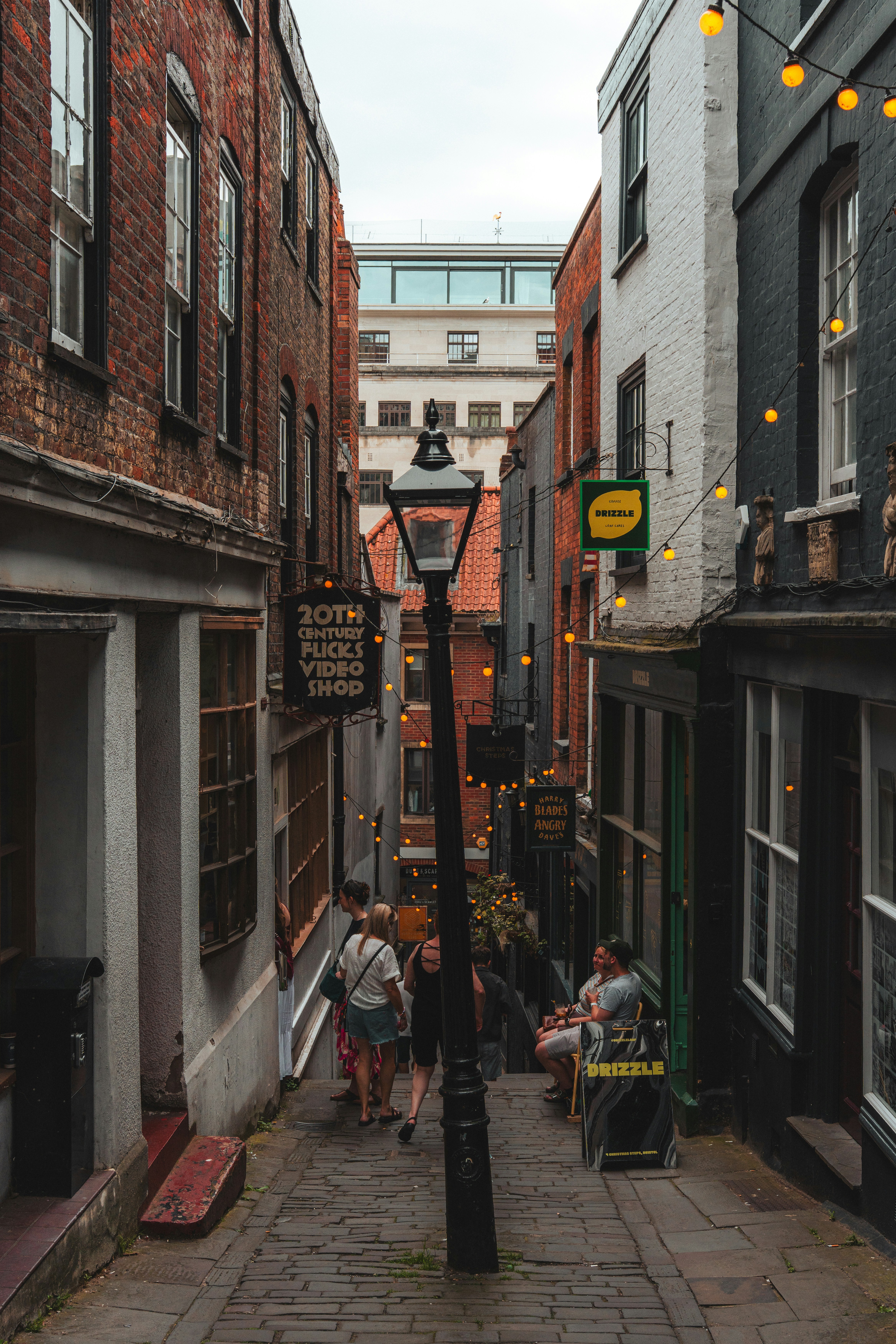 Pedestrians stroll down a charming, narrow urban alleyway