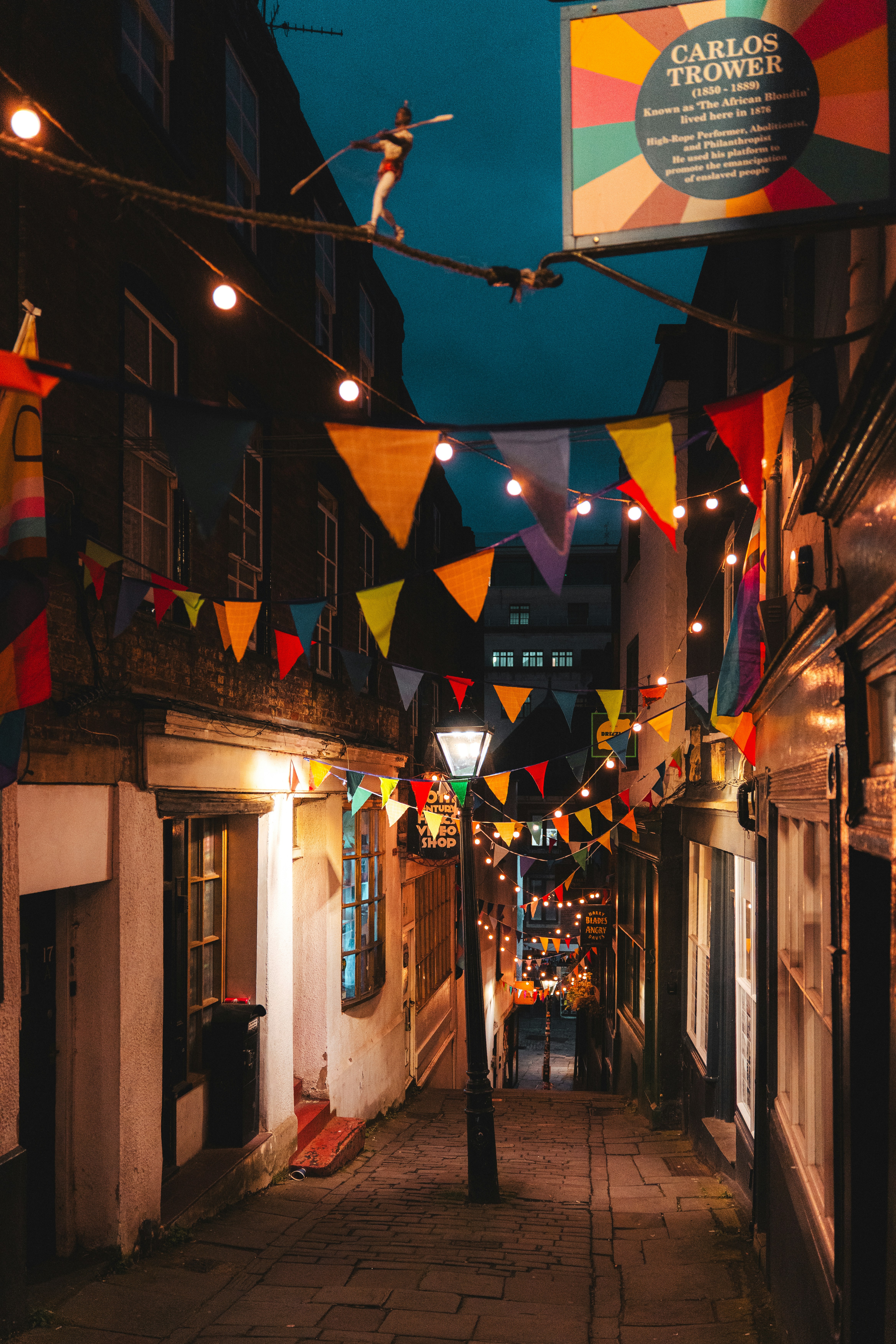 Charming alleyway with colorful bunting and string lights at night