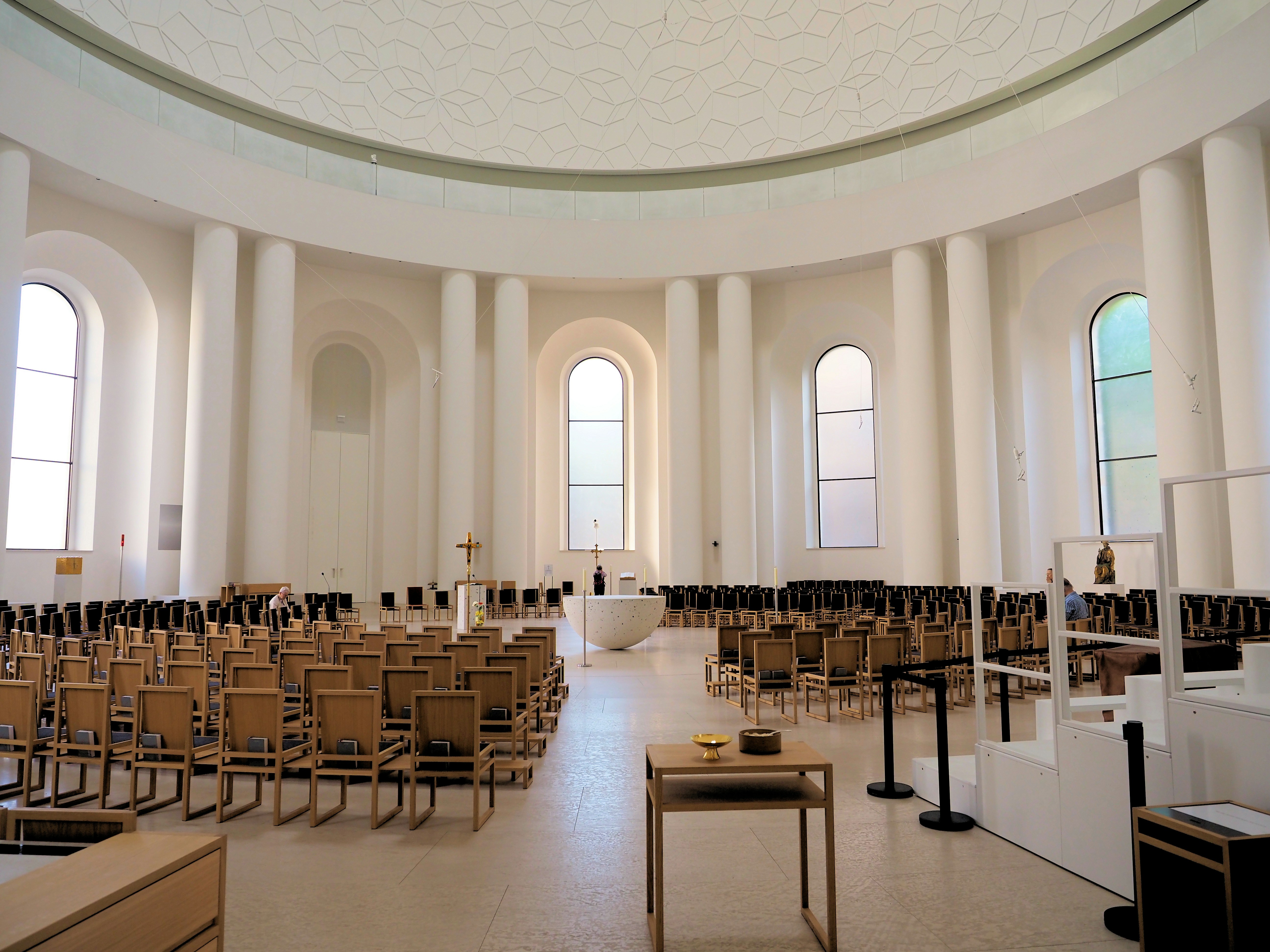 Spacious, modern circular hall with chairs, columns, and tall windows
