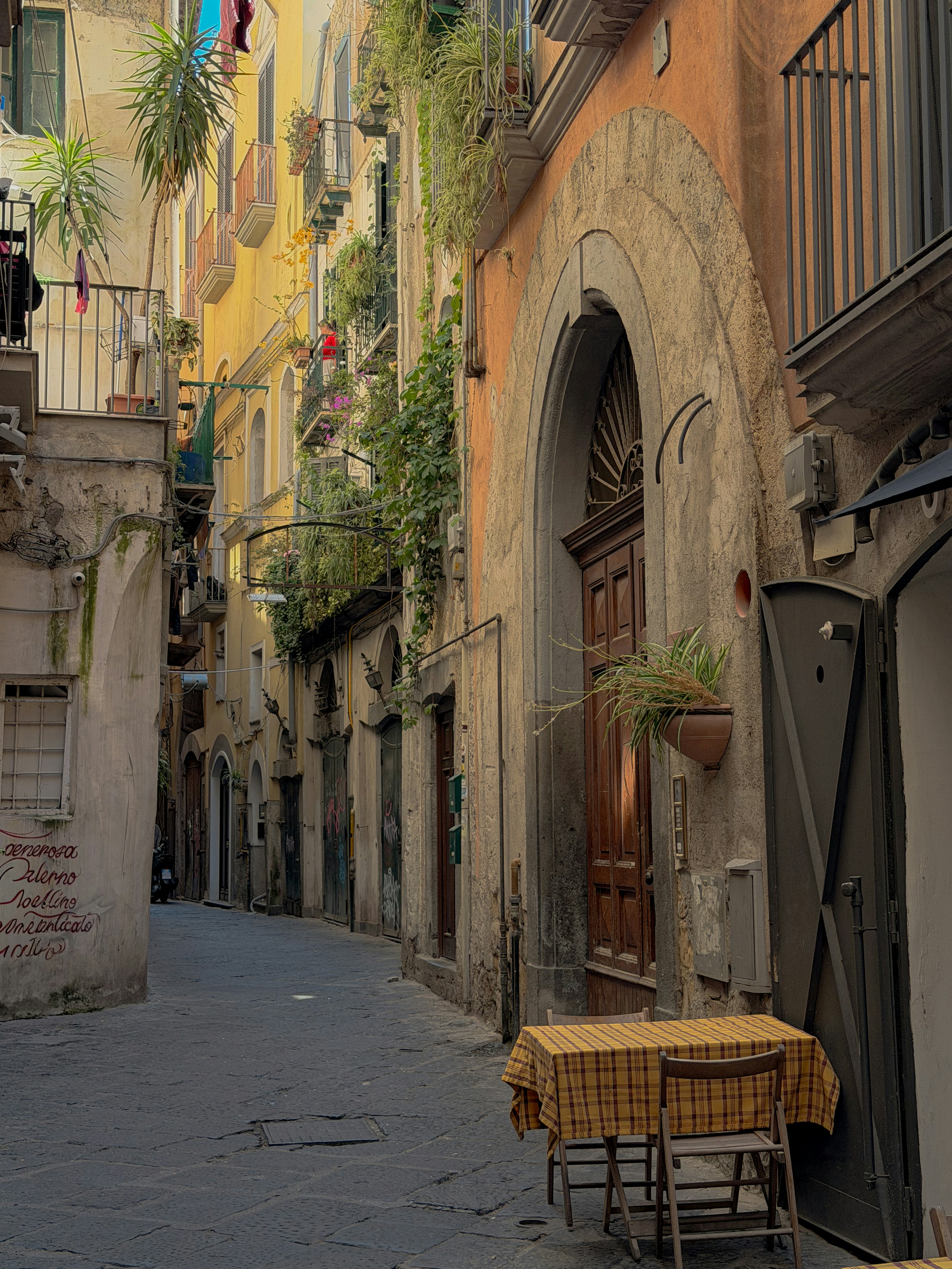 A narrow european street with old buildings and outdoor seating