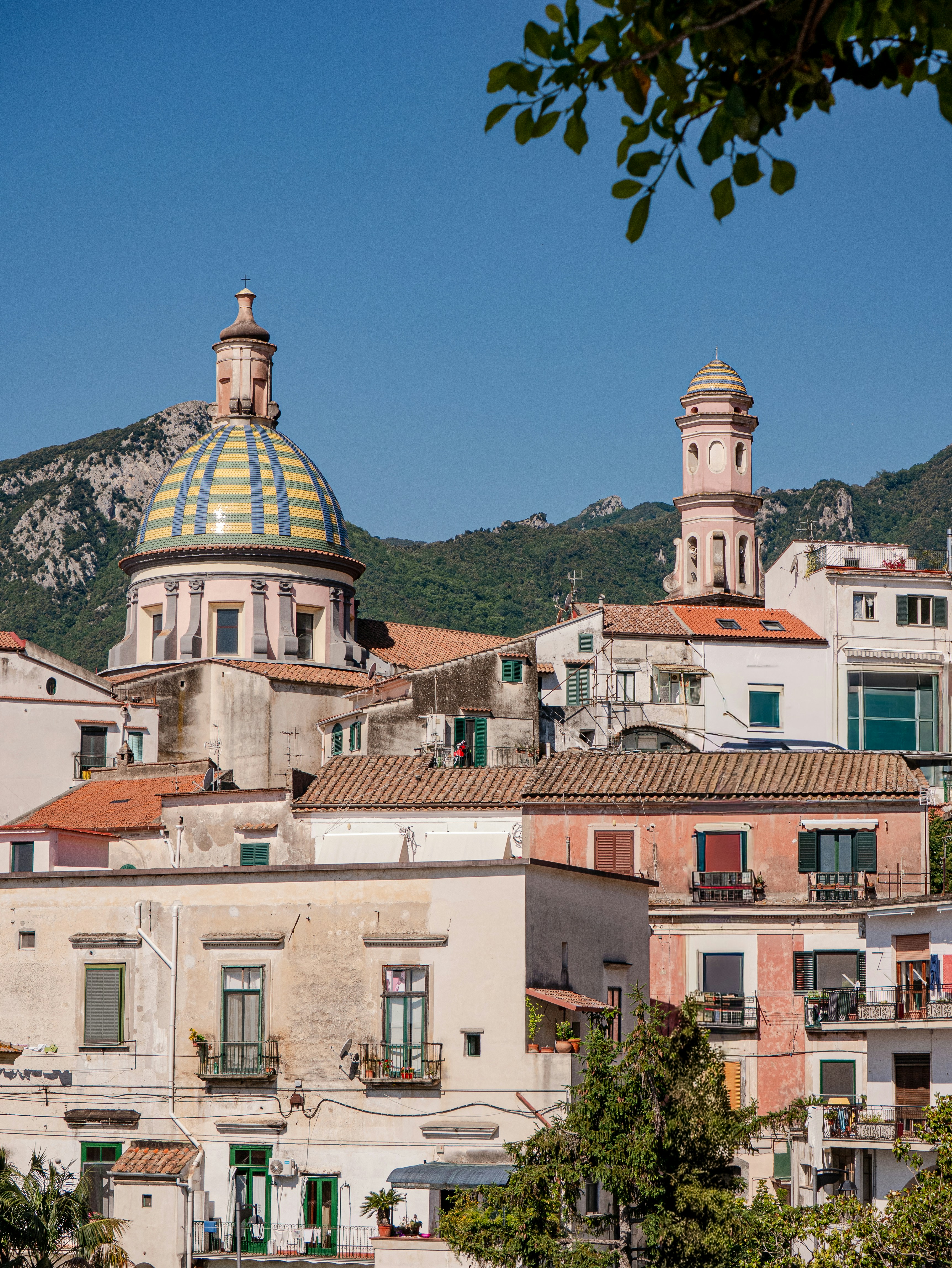 Charming town with a tiled dome, bell tower, and mountains