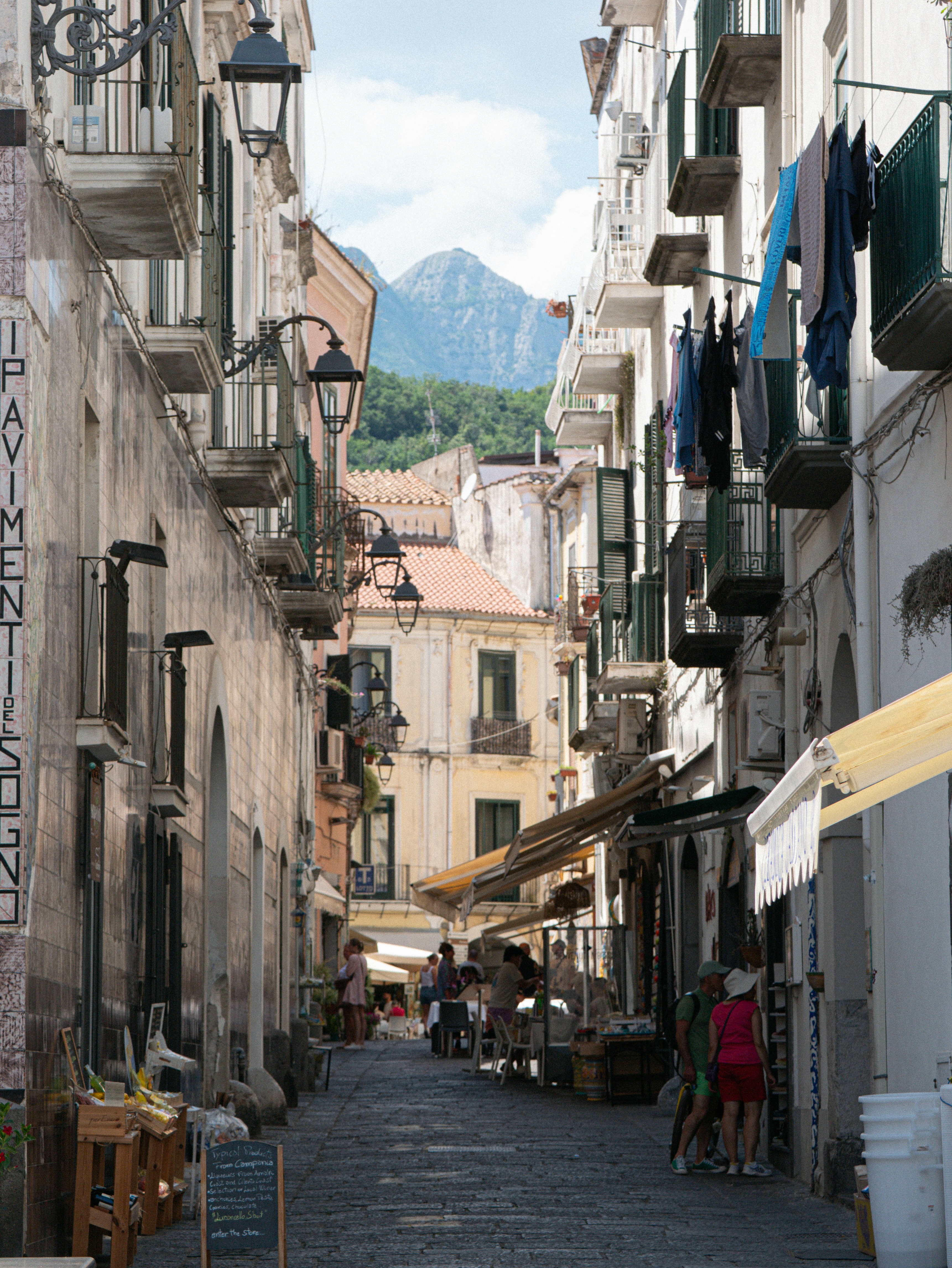 Quaint european street with shops, people, and a mountain
