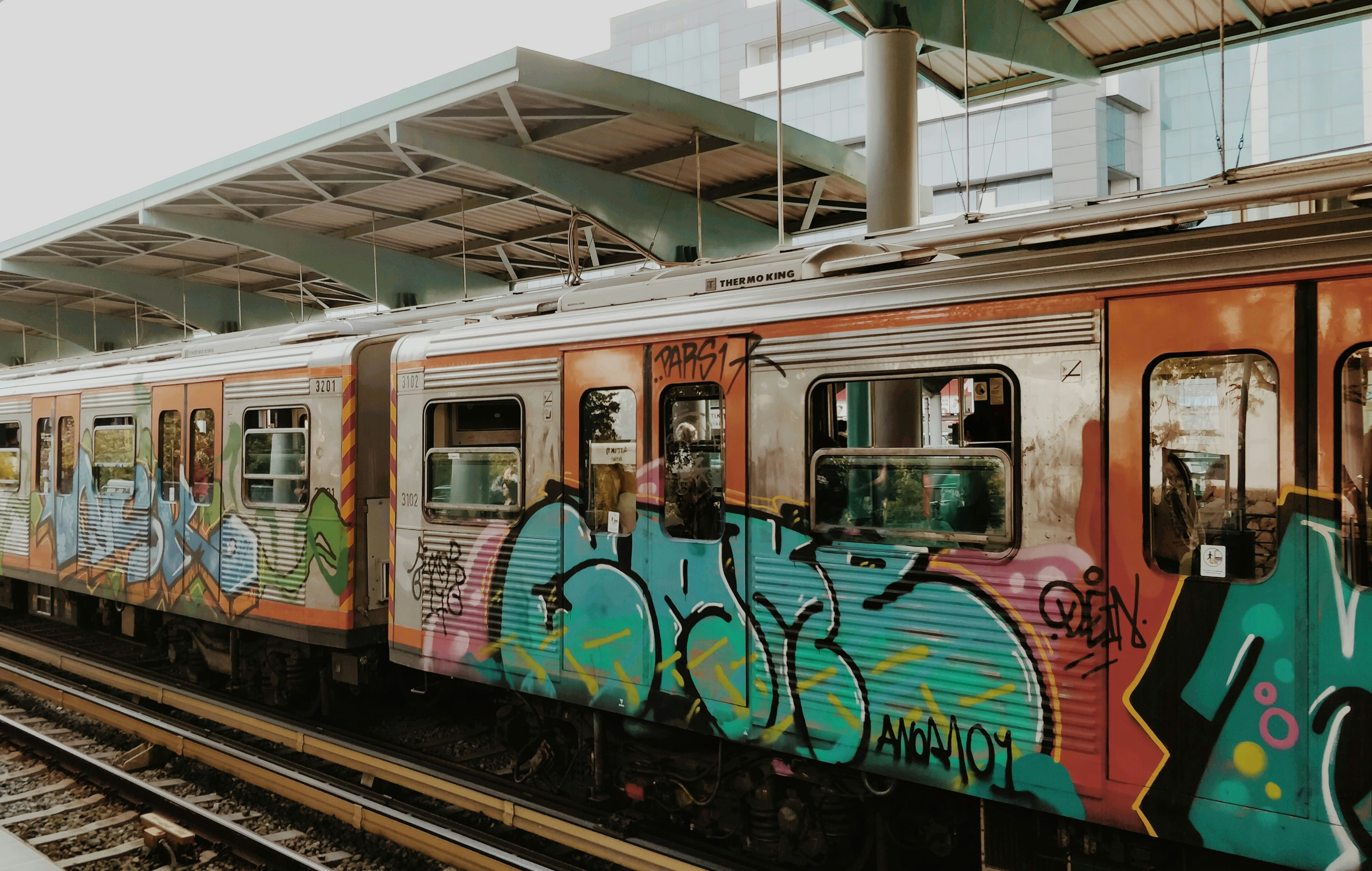 Colorful graffiti covers a subway train at a station