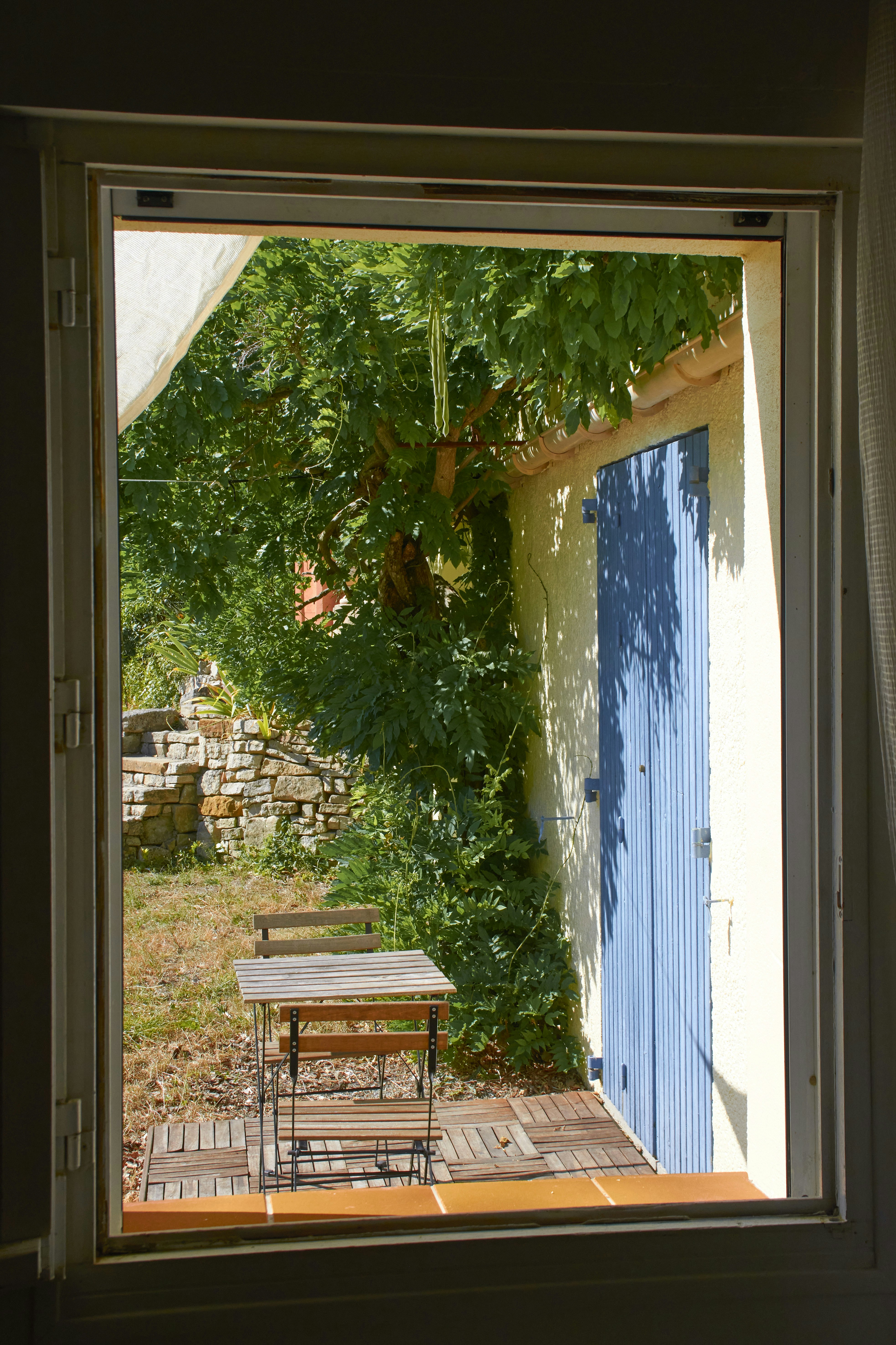 Garden with blue door and table seen through window